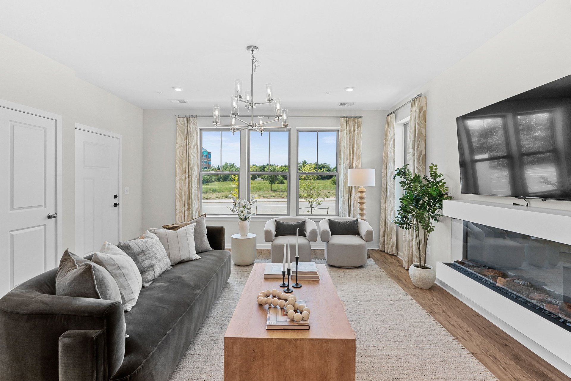 great room with a coffee table, sofa, and three windows