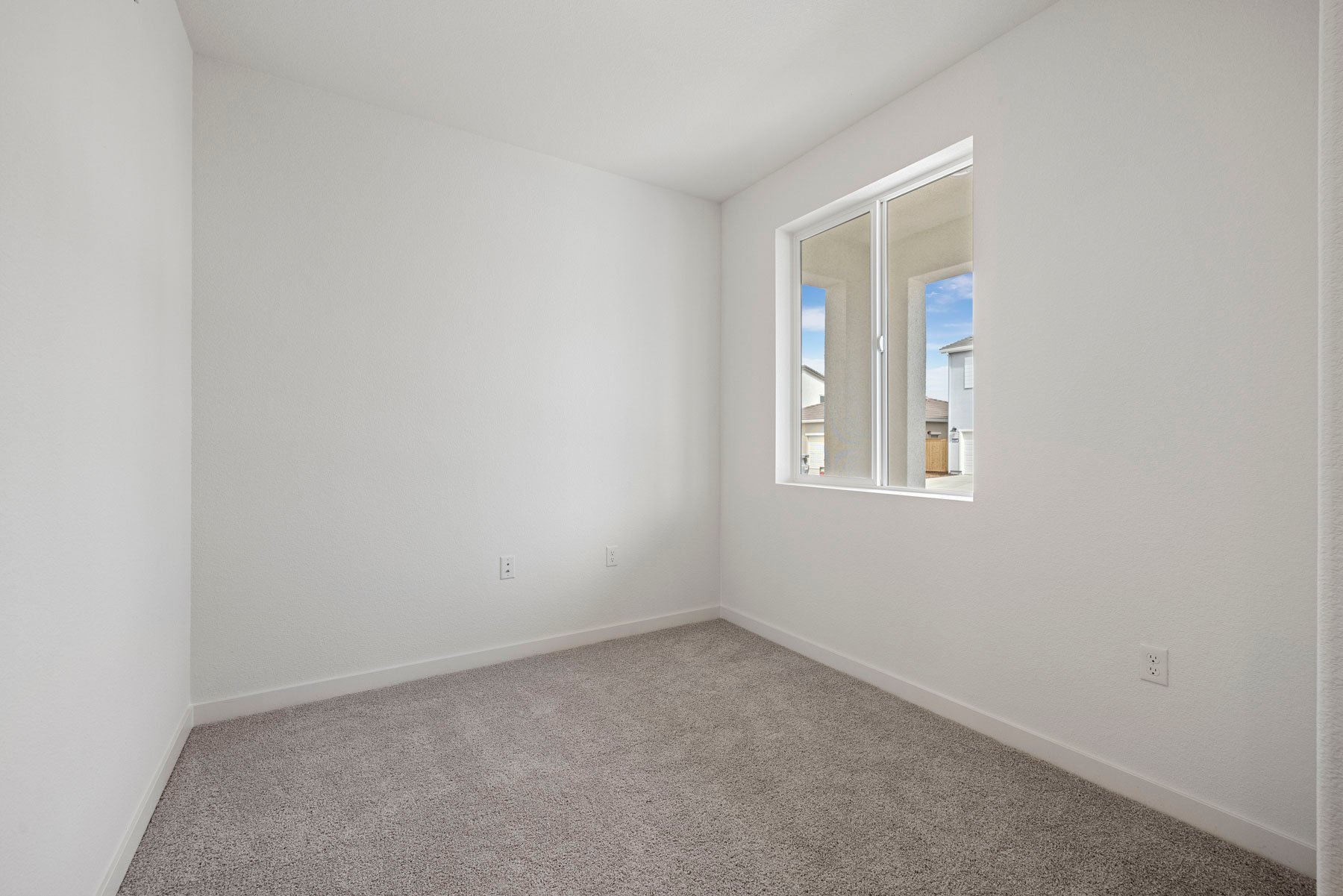study with tan carpet, white walls, and window