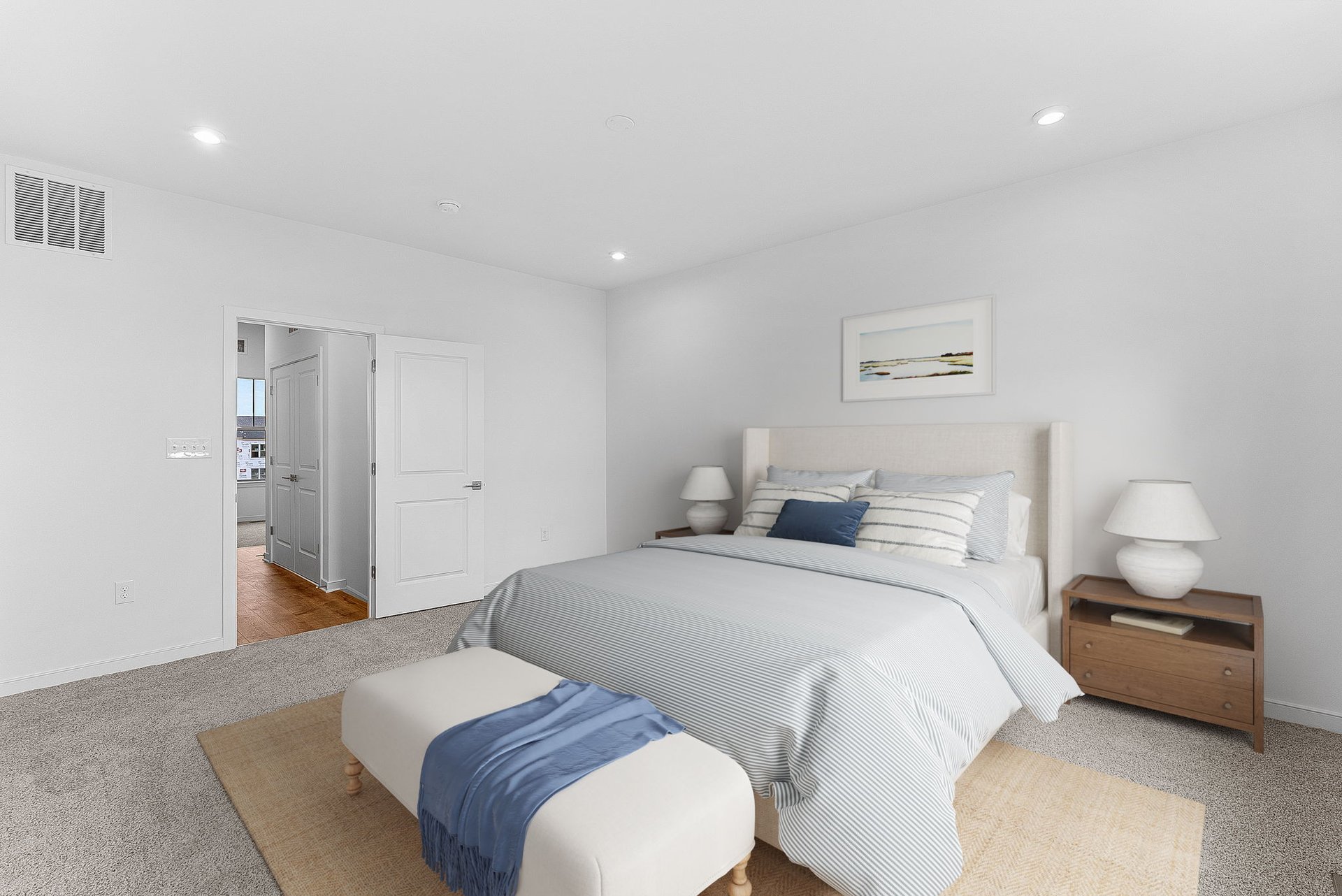 primary bedroom with a bed, a bench and two bedside tables 