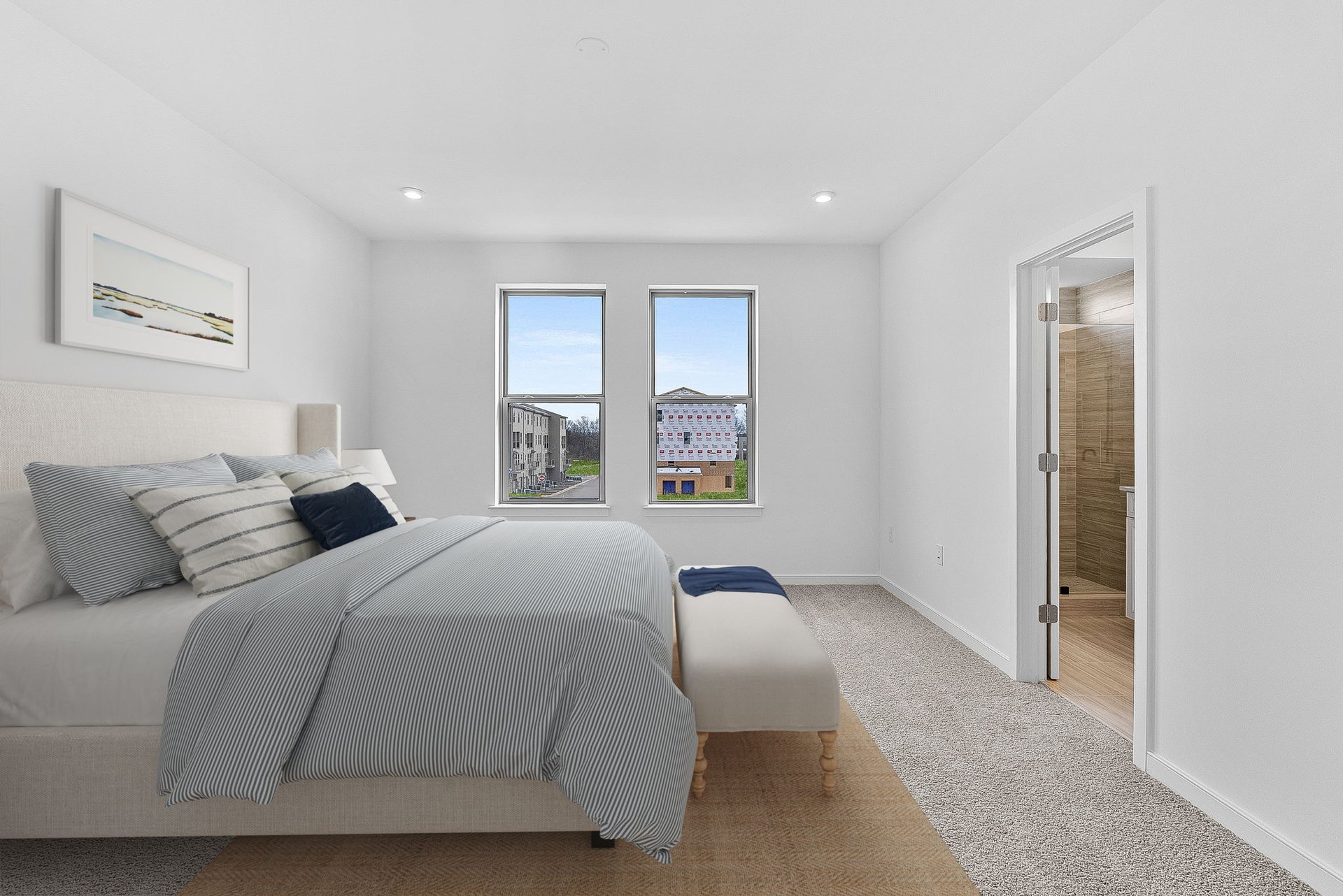 primary bedroom with two windows and carpet