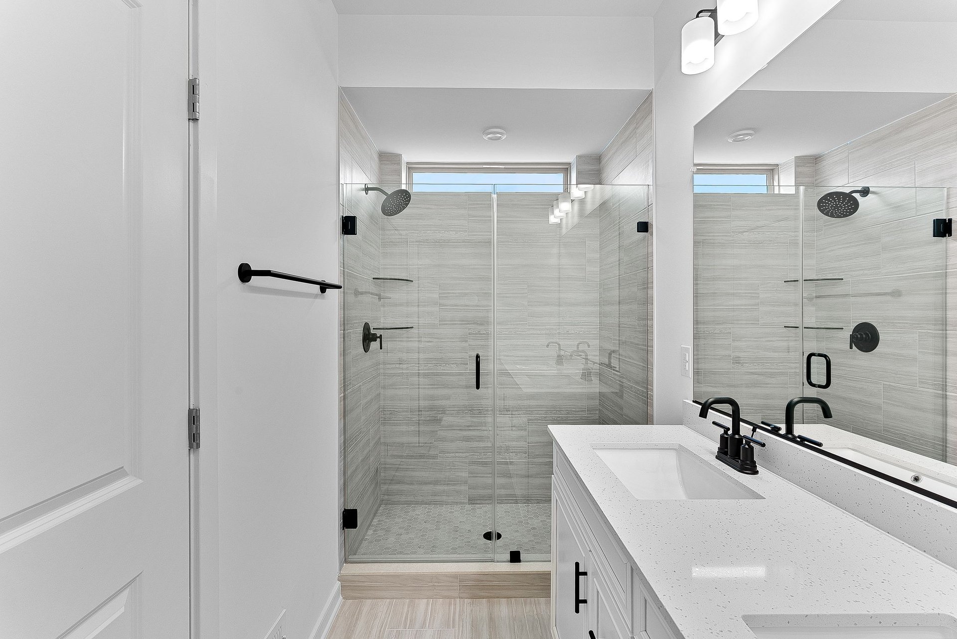 primary bathroom with a walk-in shower and a window