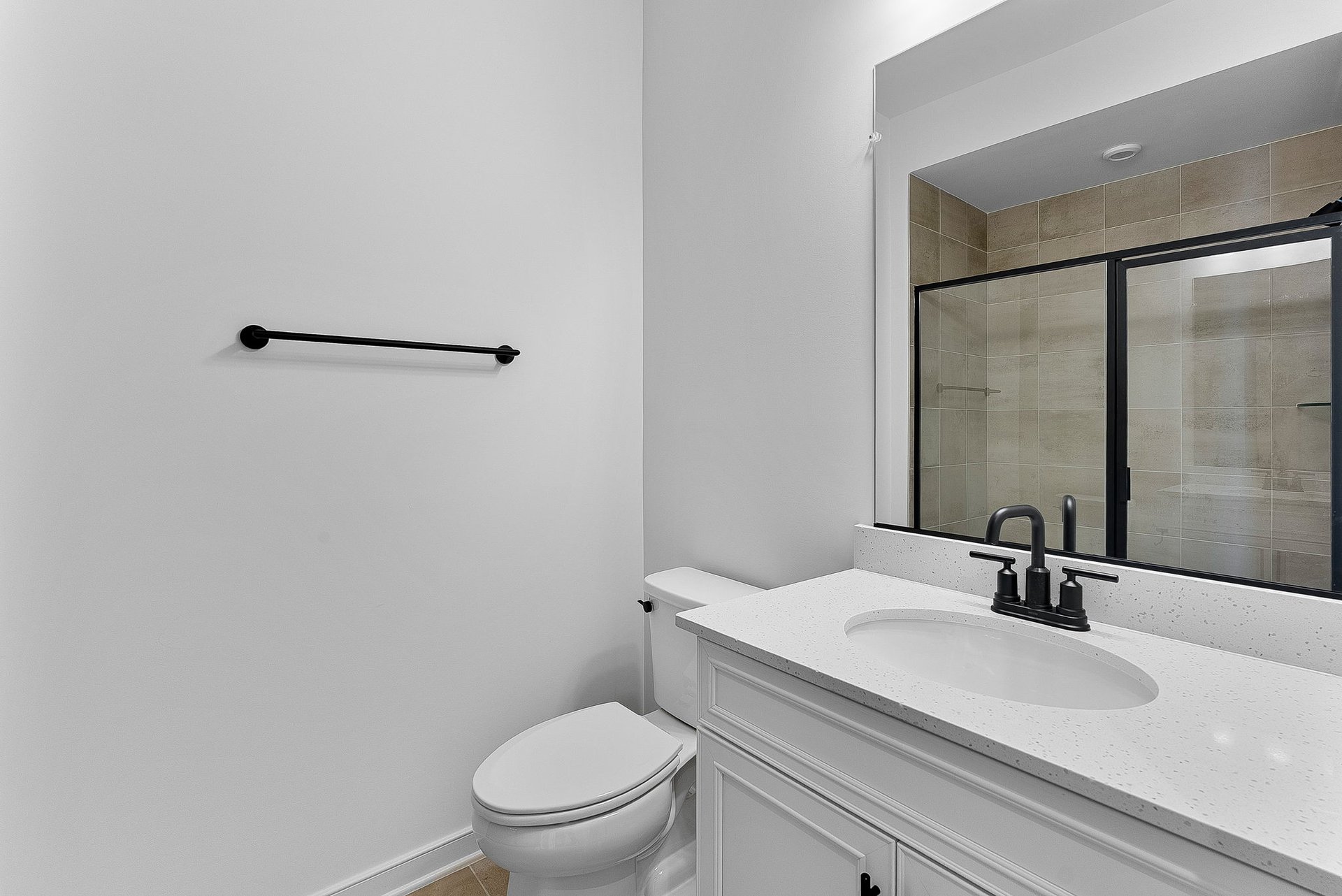 secondary bedroom with an oversized shower and a large mirror