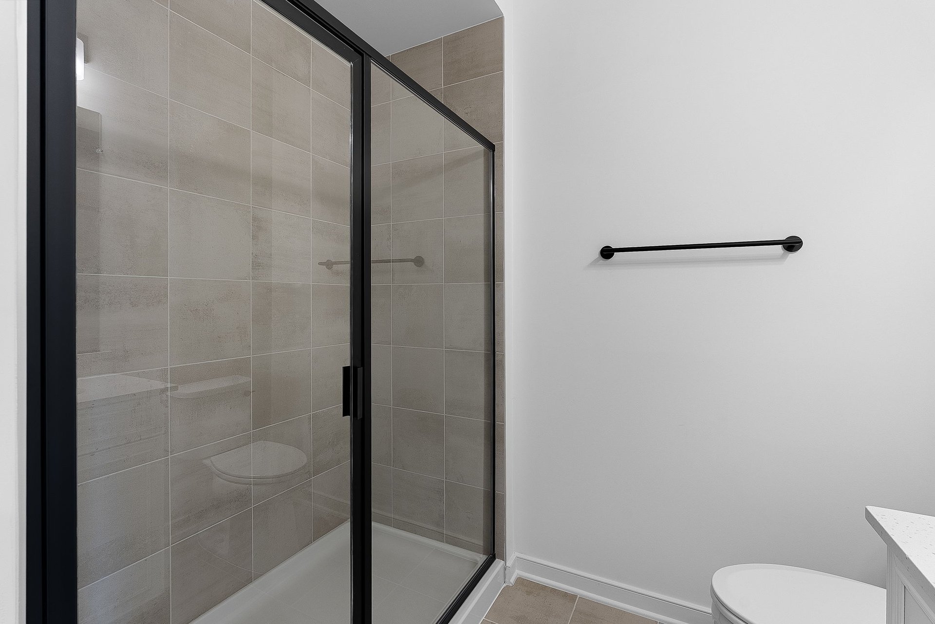 secondary bathroom with a walk-in shower with tile walls