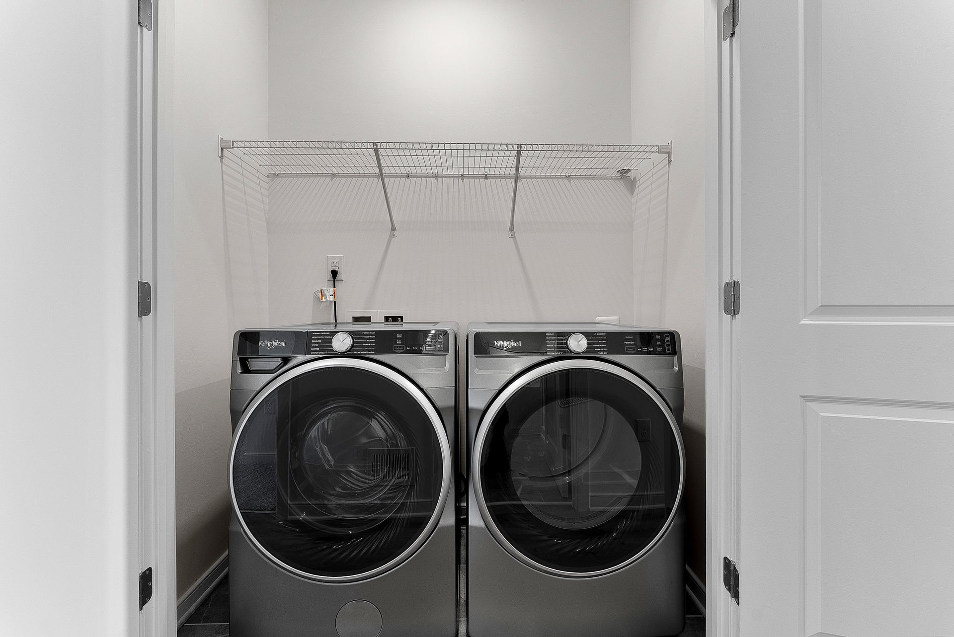 laundry room with a washer, dryer and a wire shelf