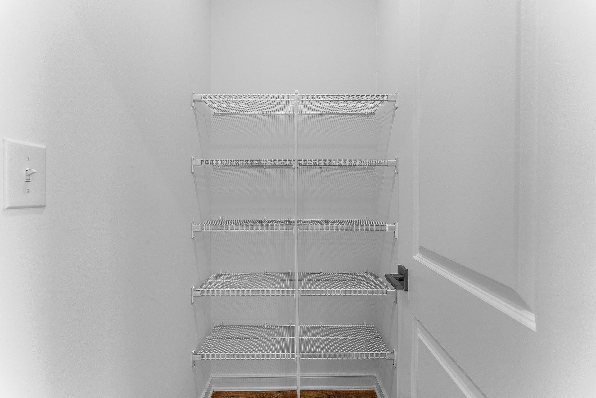 walk-in pantry with five wire shelves and a light