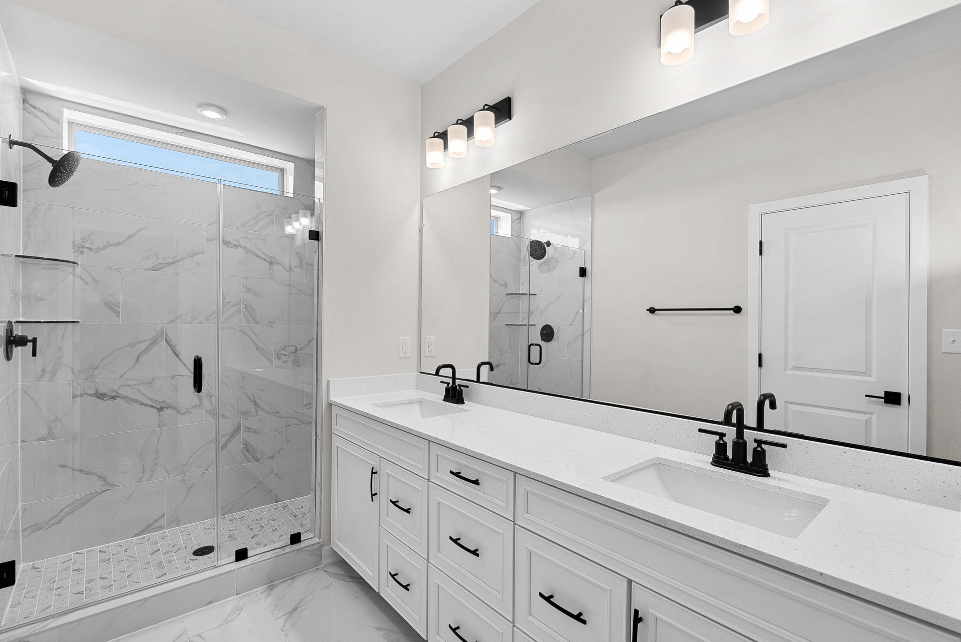primary bathroom with two sinks and an oversized shower