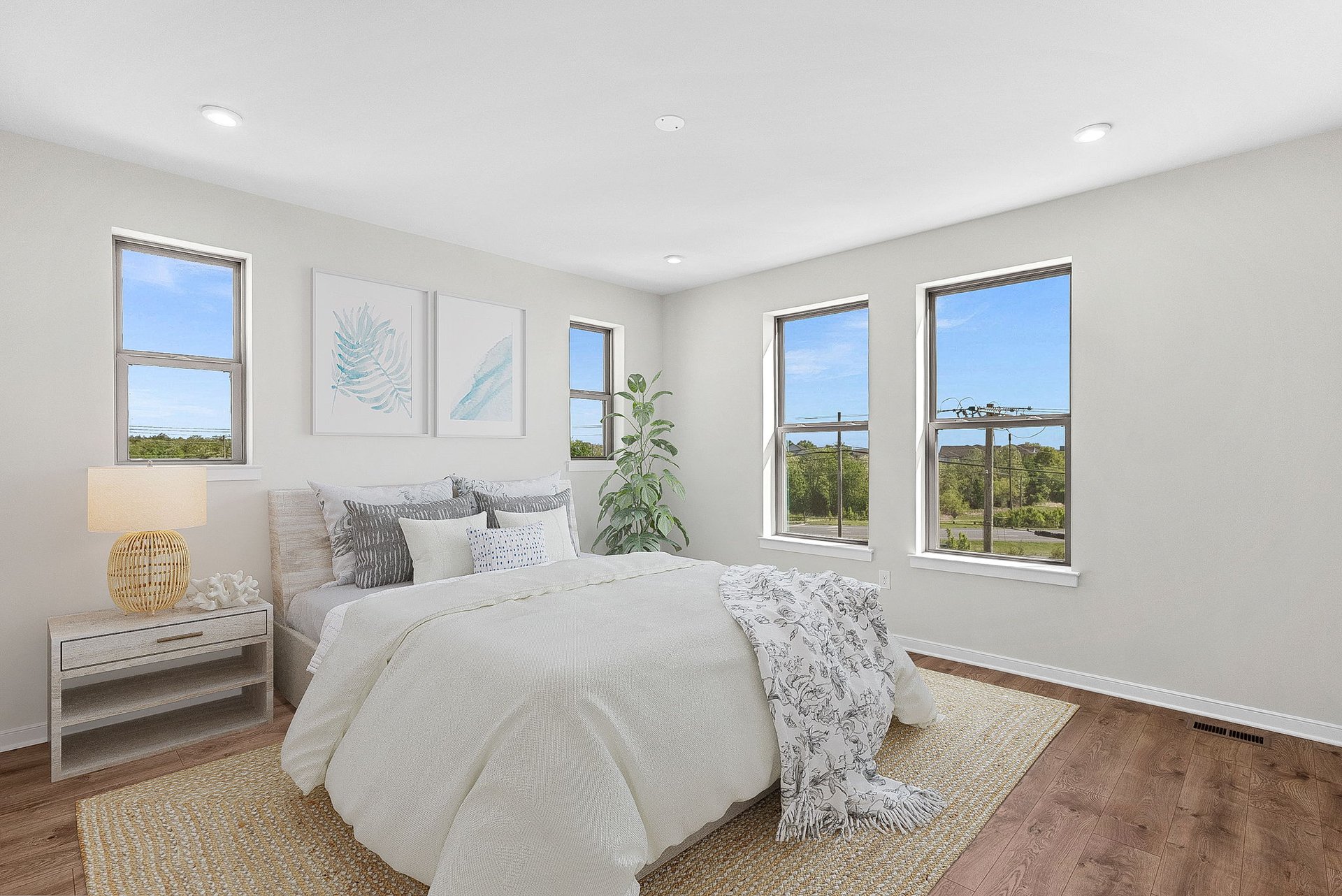 primary bedroom with a rug and several windows