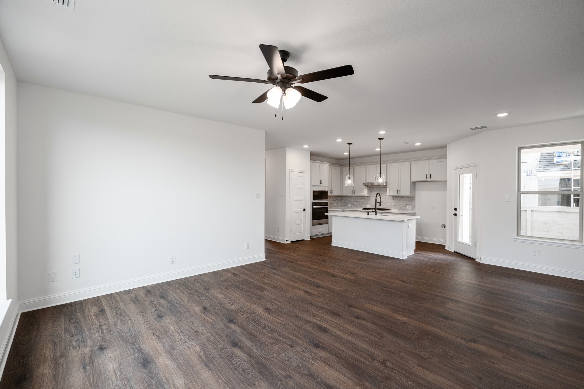 open great room with wood floors and ceiling fan