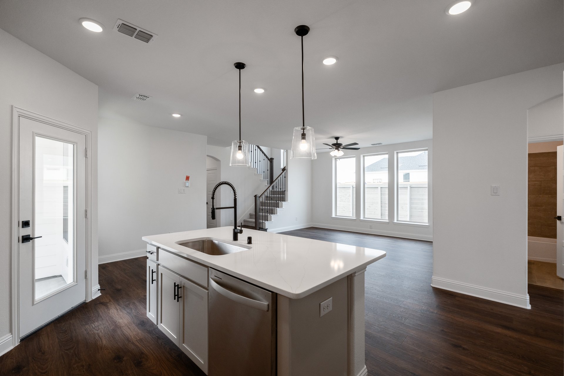 open kitchen with wood floors and white cabinets