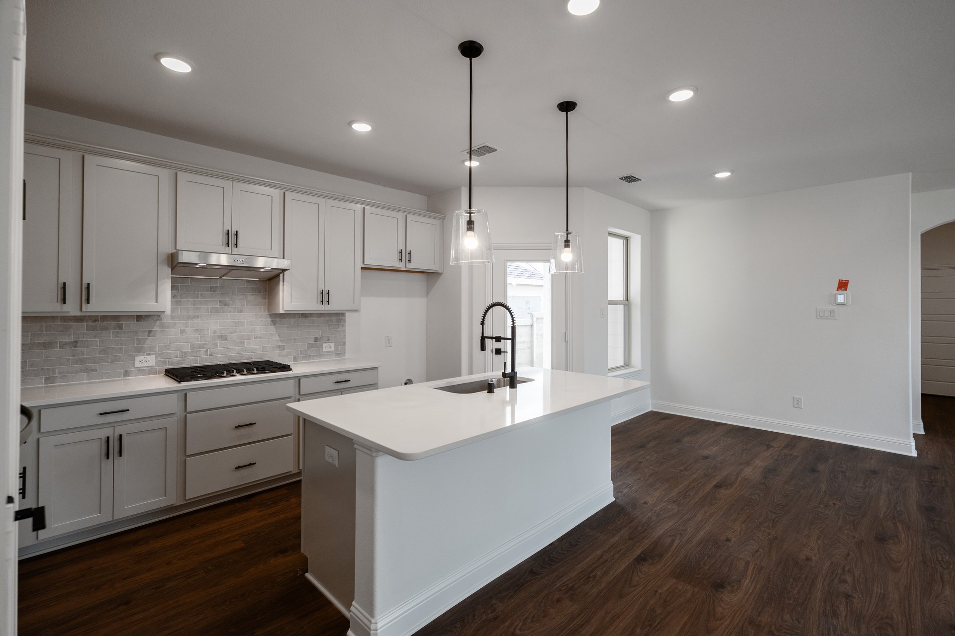 open kitchen with wood floors and white cabinets
