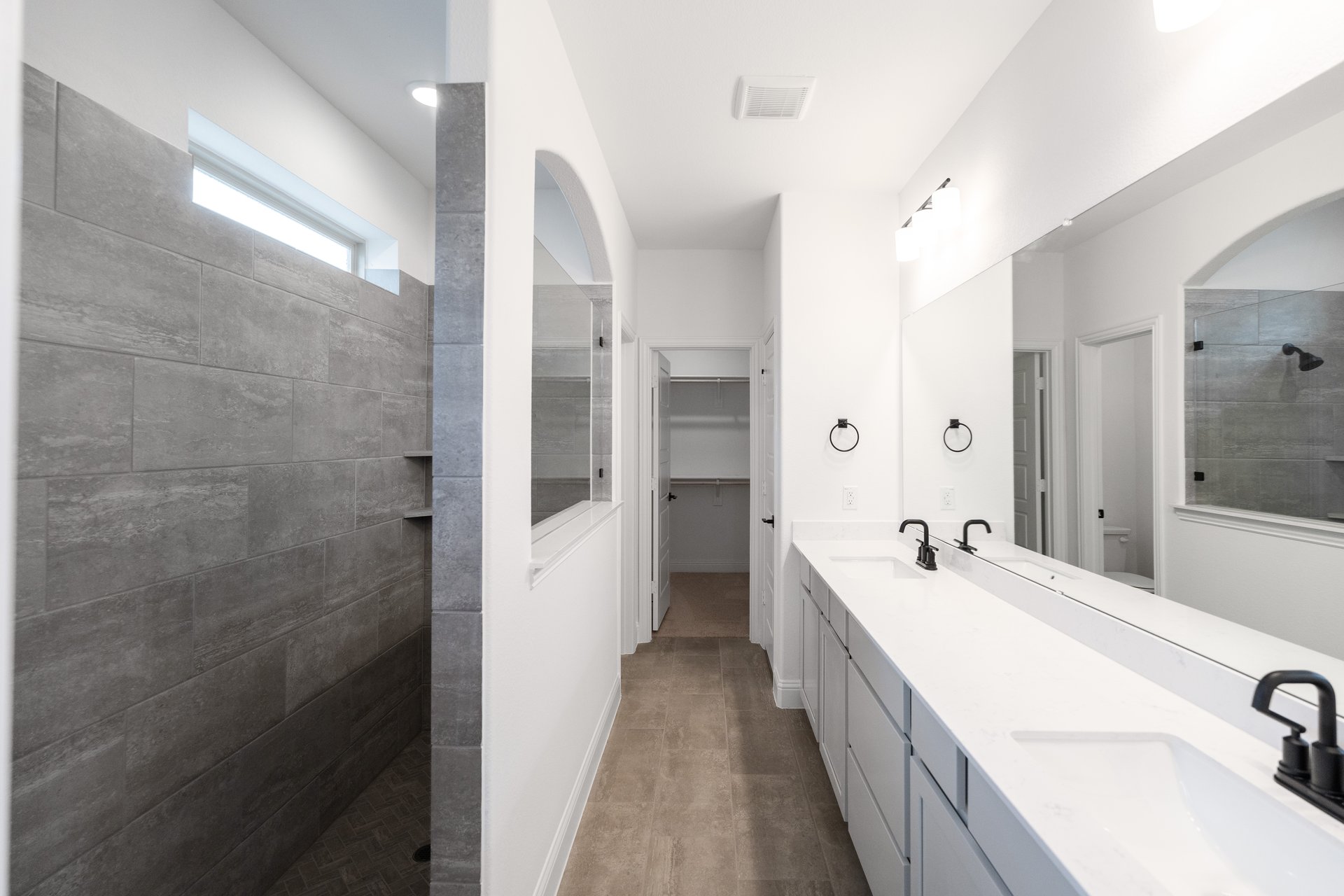 primary bathroom with walk-in shower and tile floors