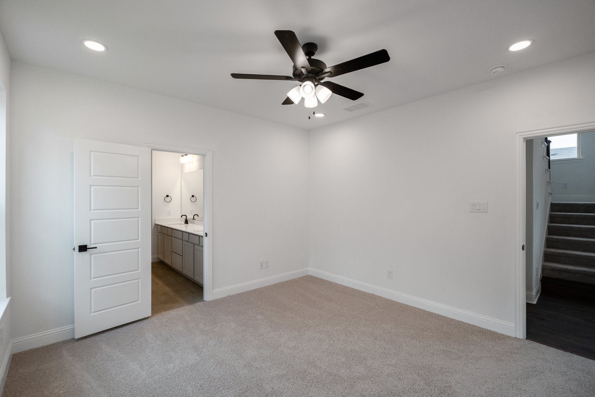 primary bedroom with carpet and ceiling fan