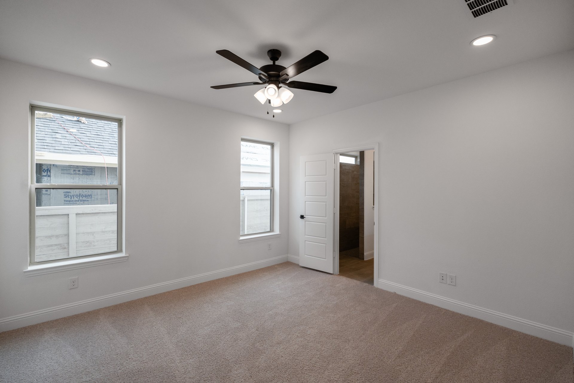 primary bedroom with carpet and windows