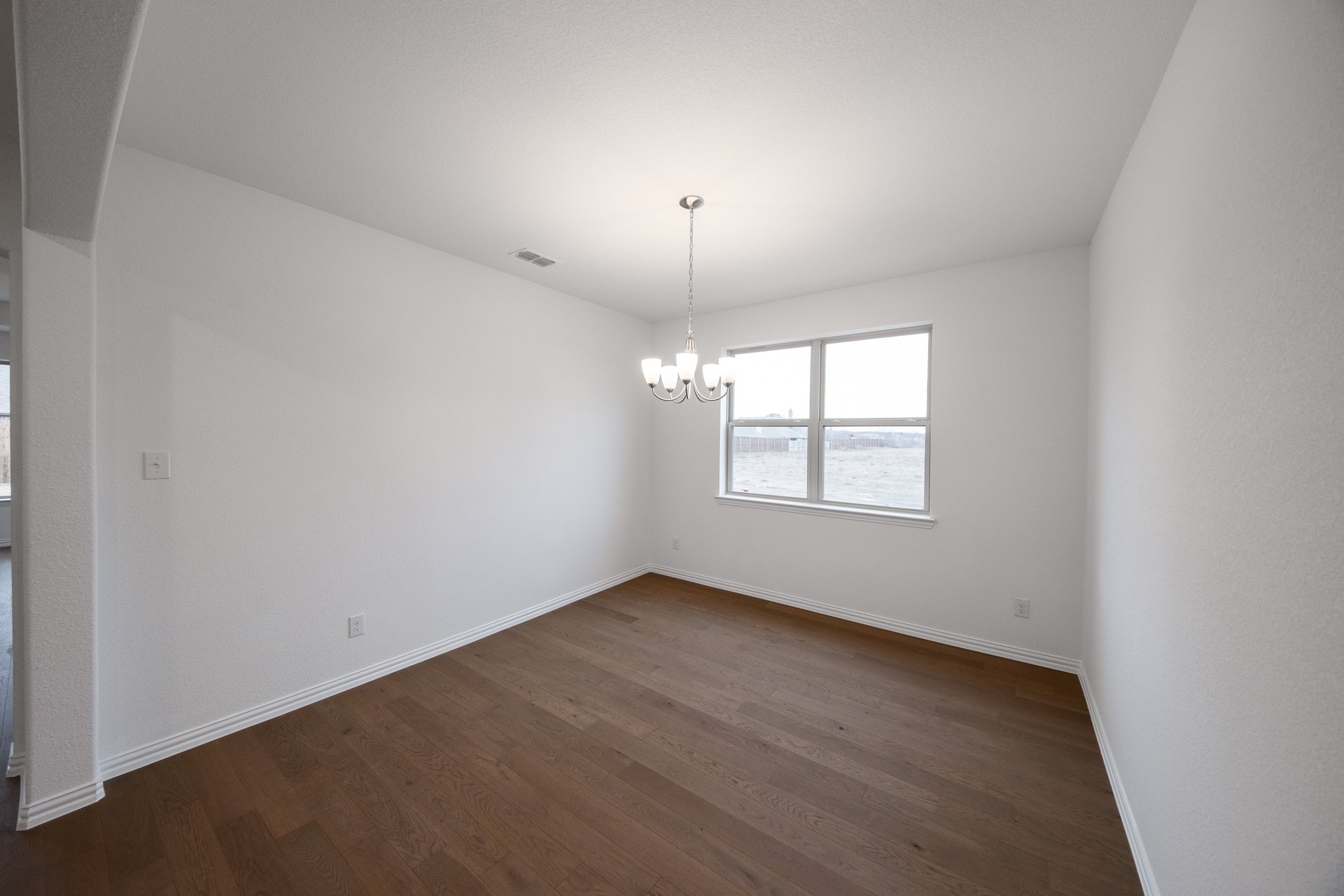 open dining room with wood floors and windows