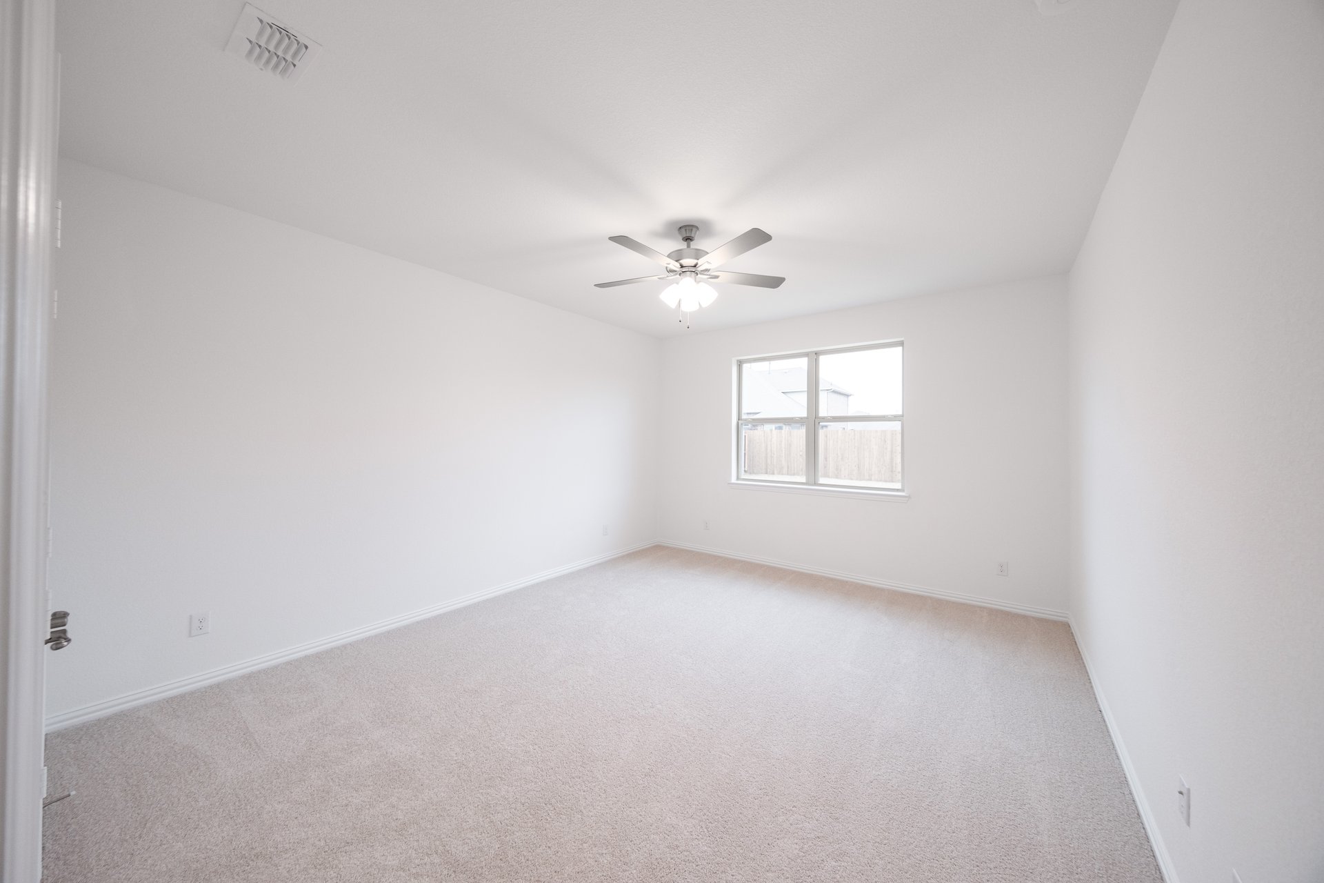 primary bedroom with carpet and windows