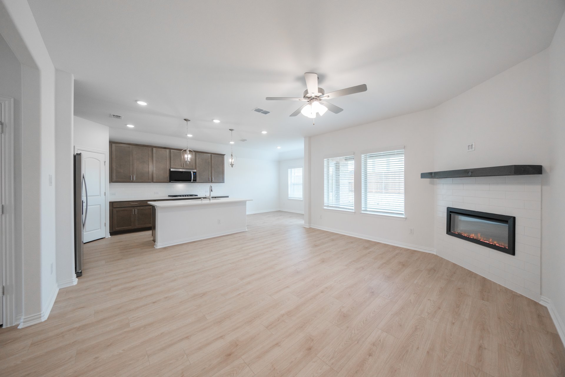 open great room with wood floors and fireplace