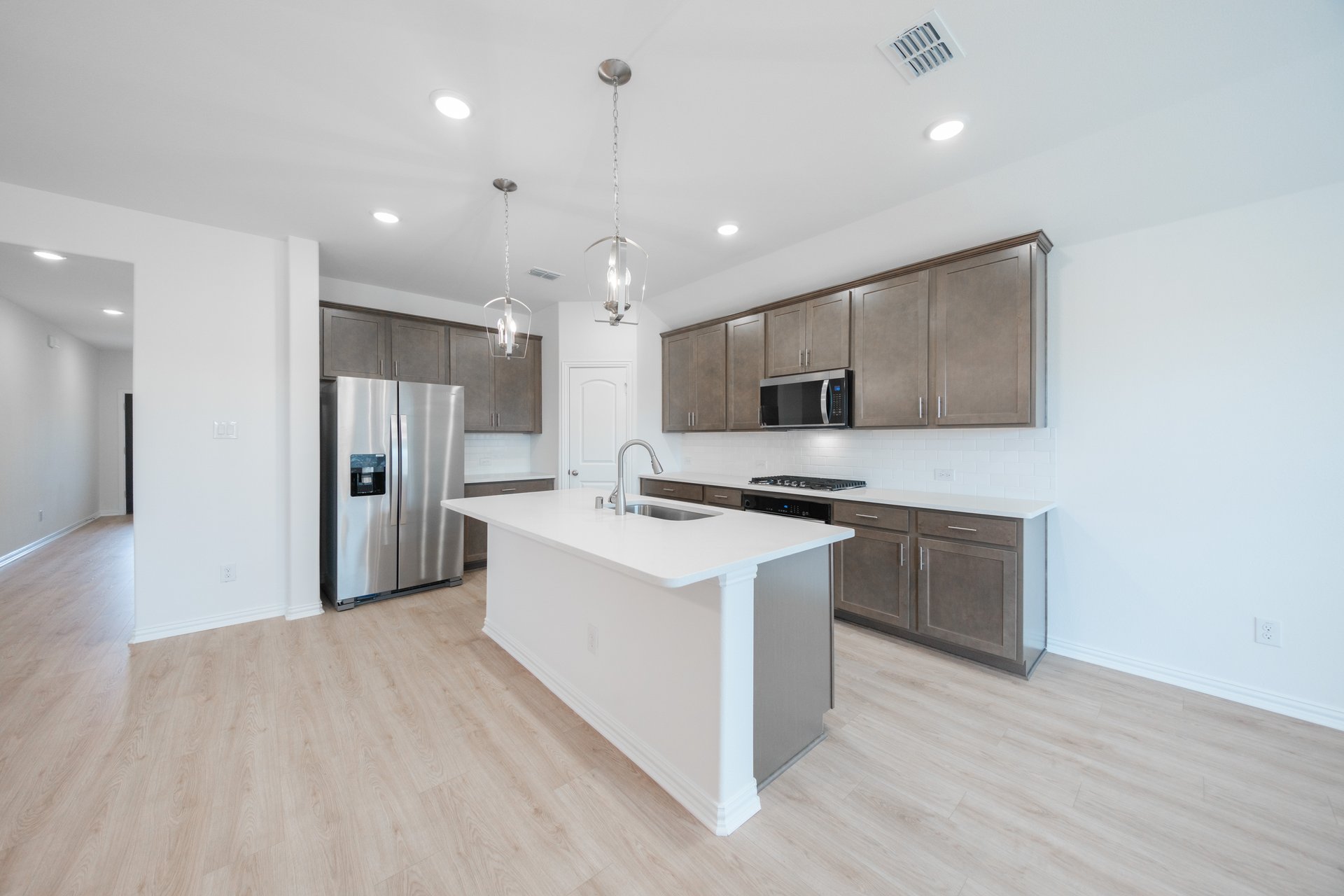 open kitchen with wood floors and island