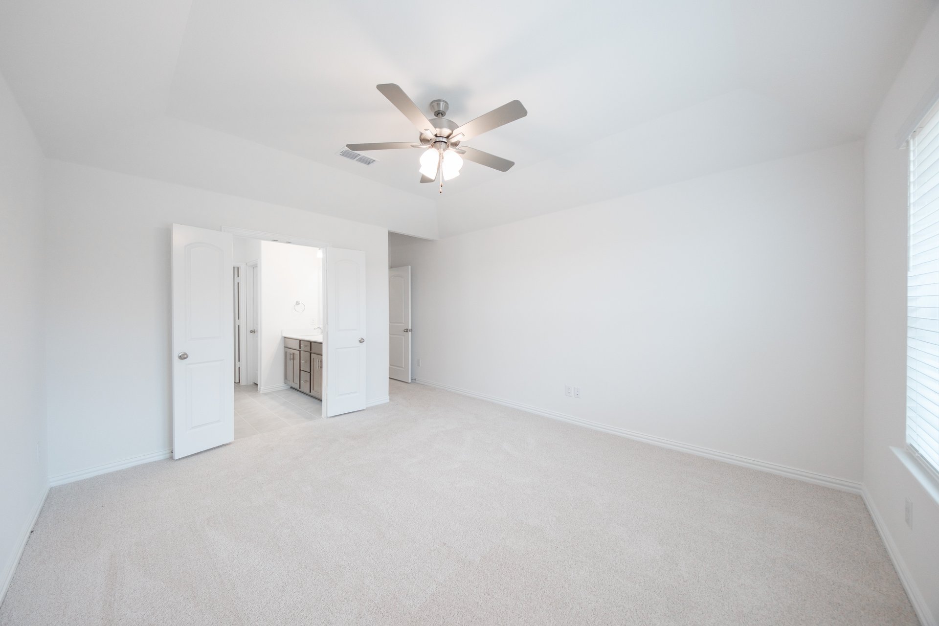 primary bedroom with carpet and ceiling fan