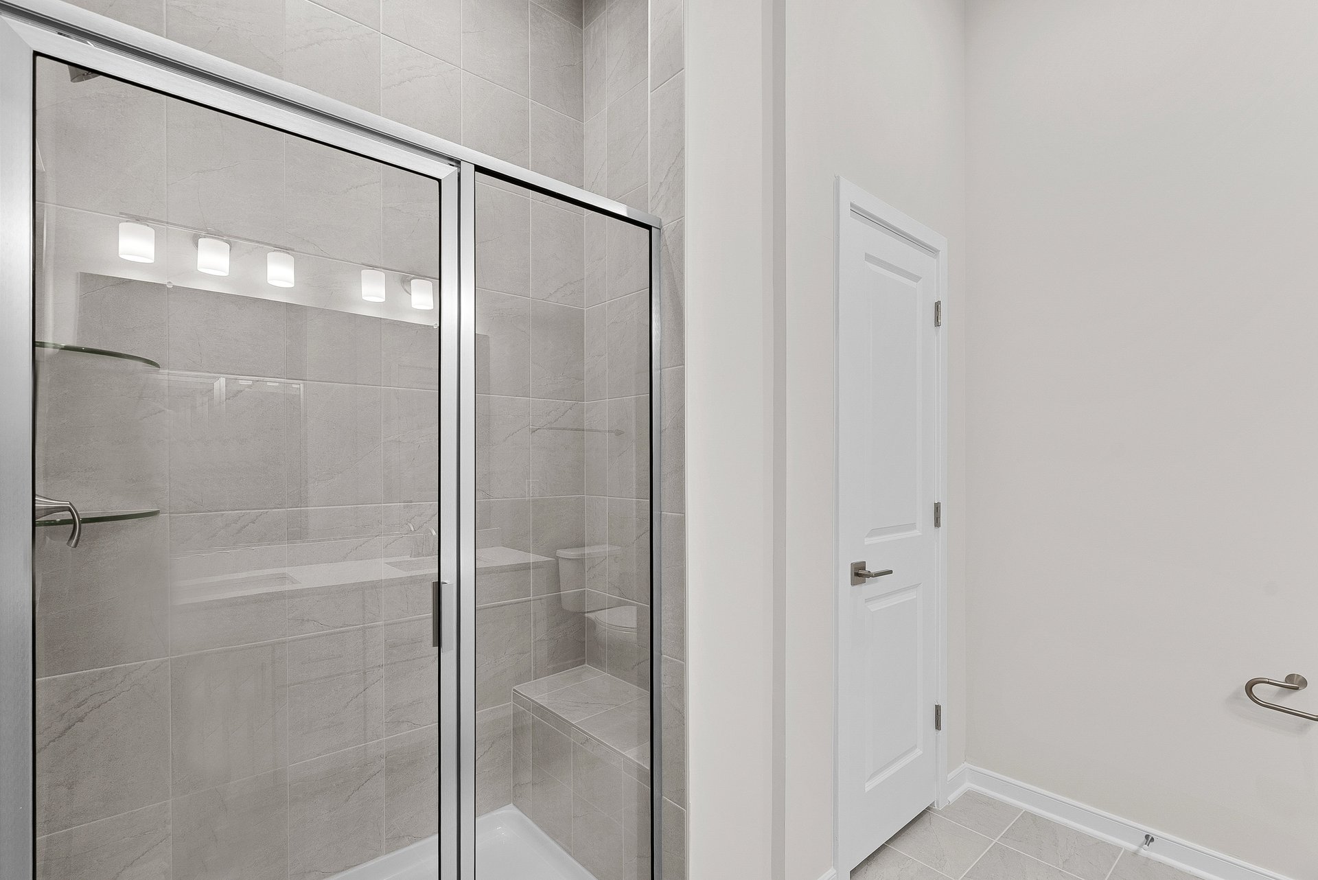 primary bathroom with shower with steel frames and closet