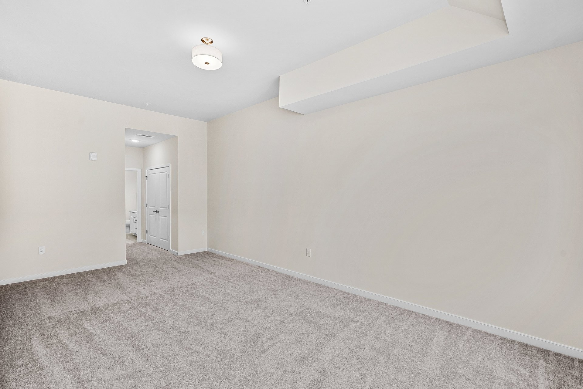 primary bedroom with overhead lighting and carpet