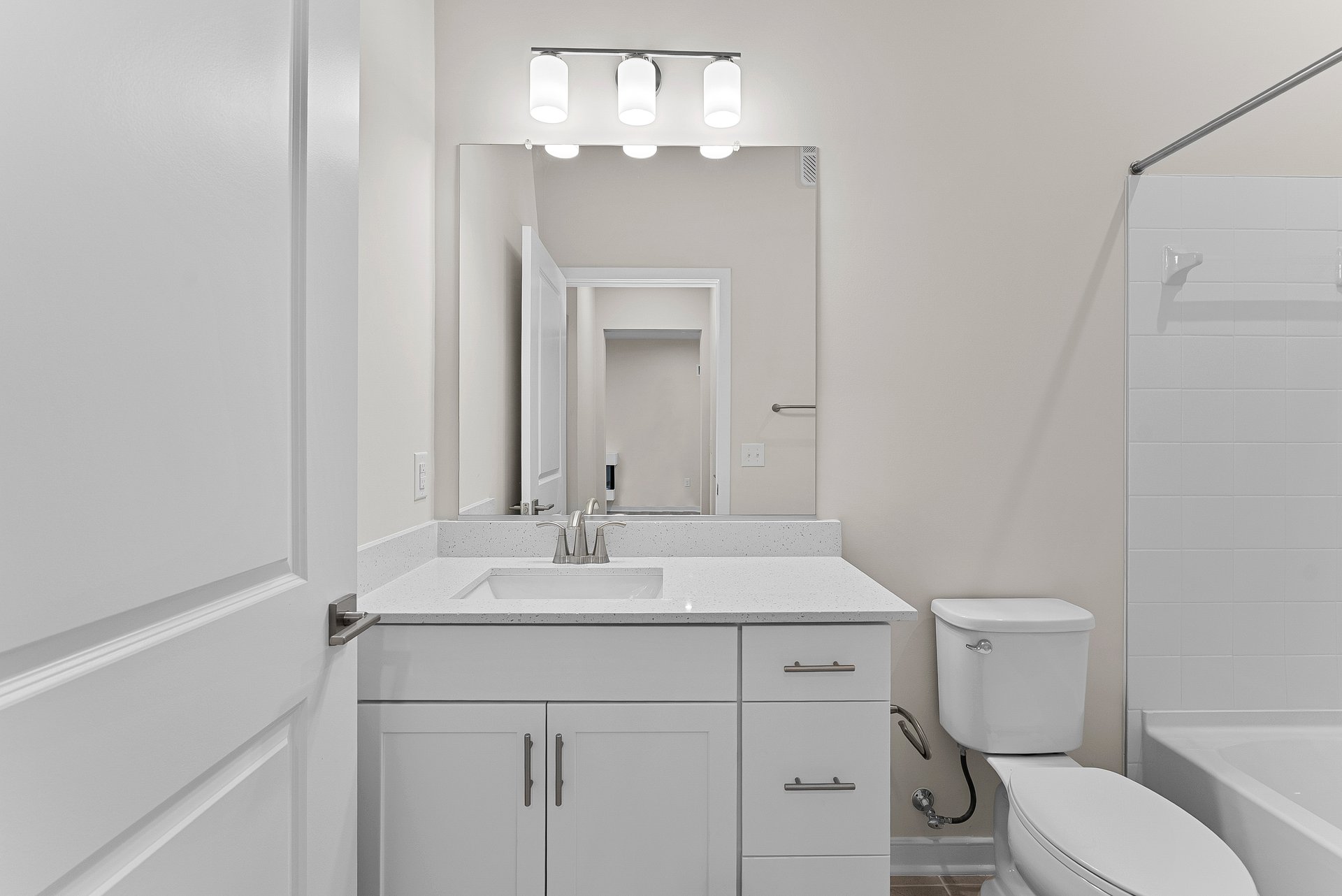 secondary bedroom with white cabinets, sink, and mirror
