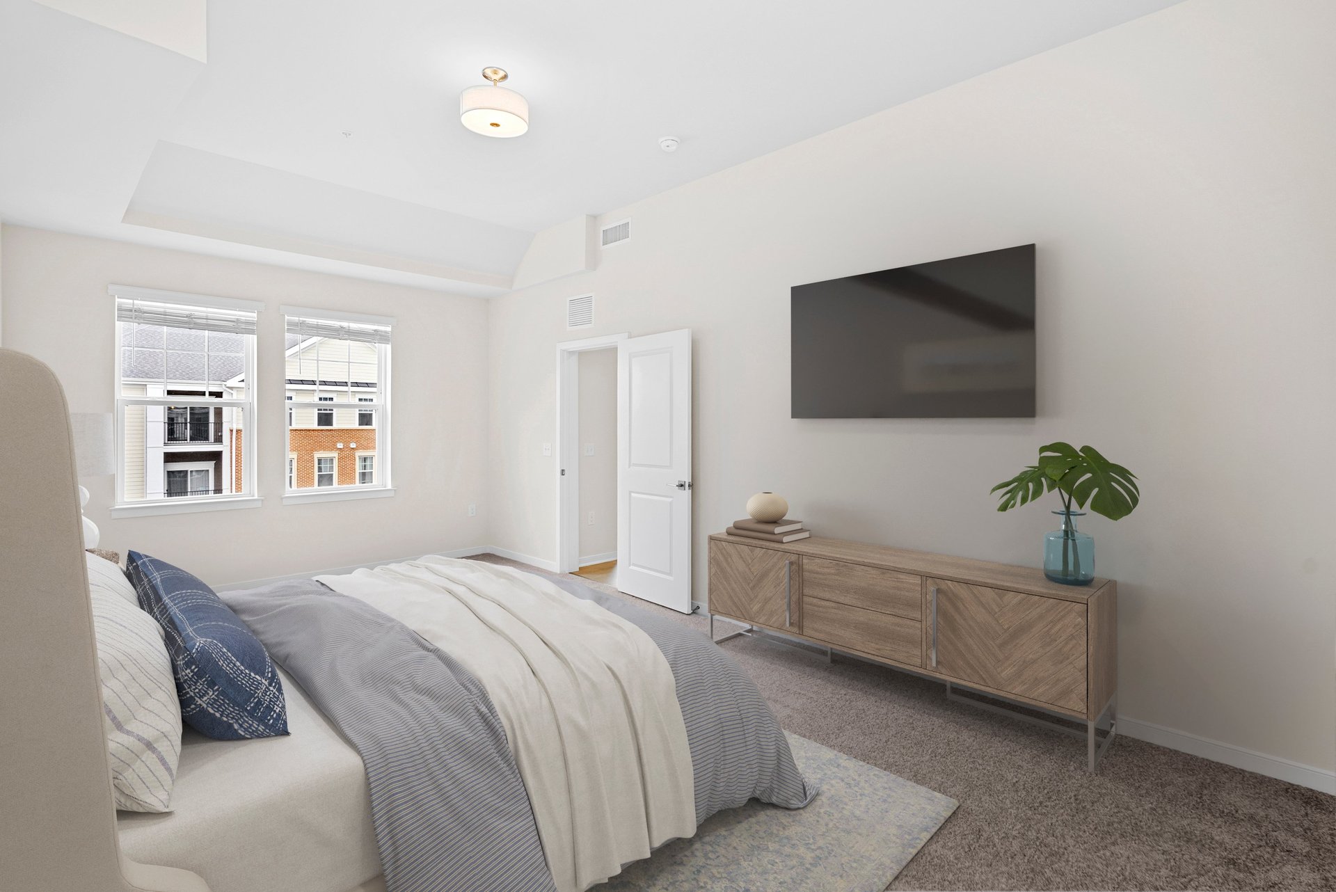 primary bedroom with queen bed and tv