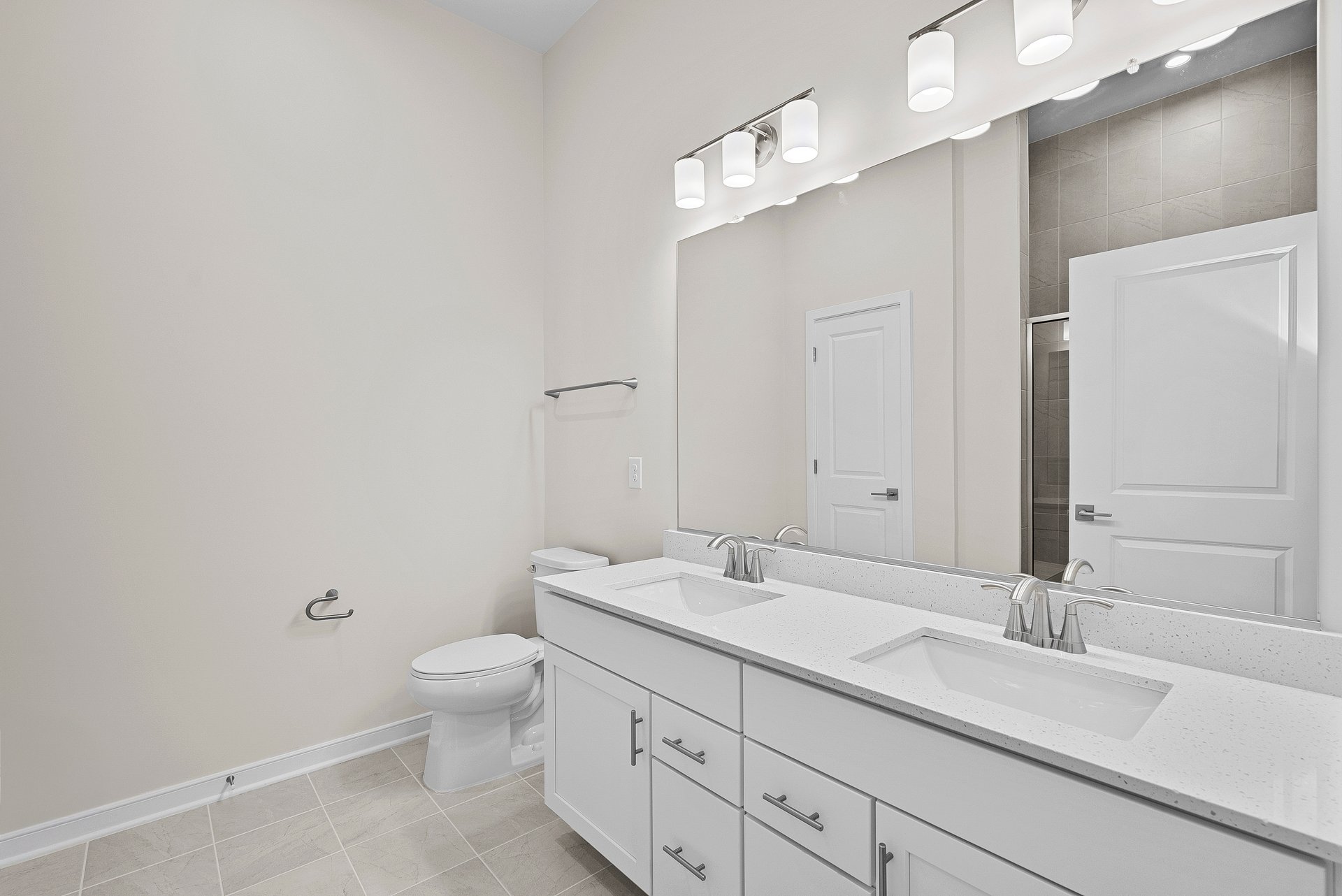 primary bathroom with white cabinets and mirror