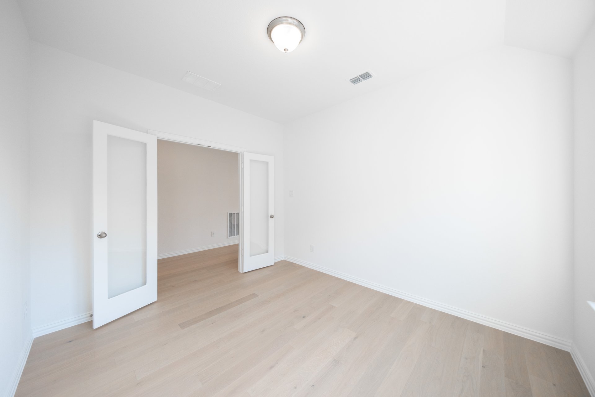 study with french doors and hard wood flooring