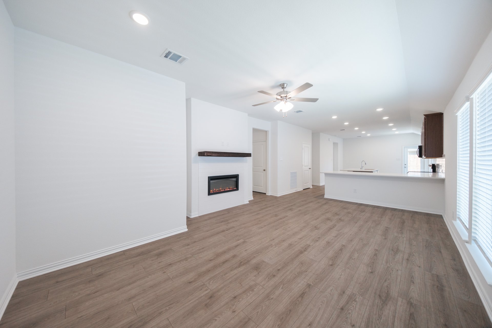 open great room with wood floors and fireplace