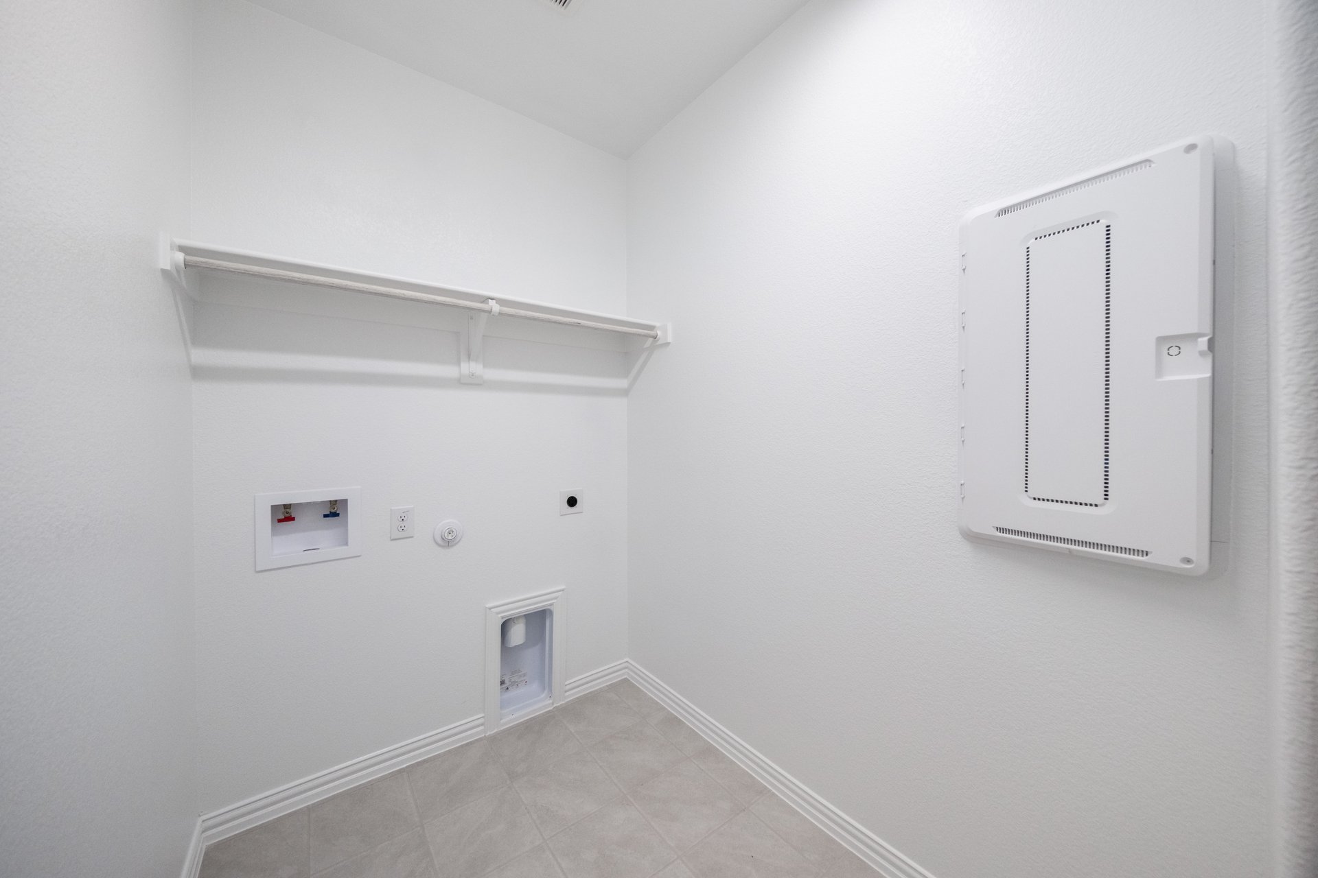 laundry room with tile floors and white shelf
