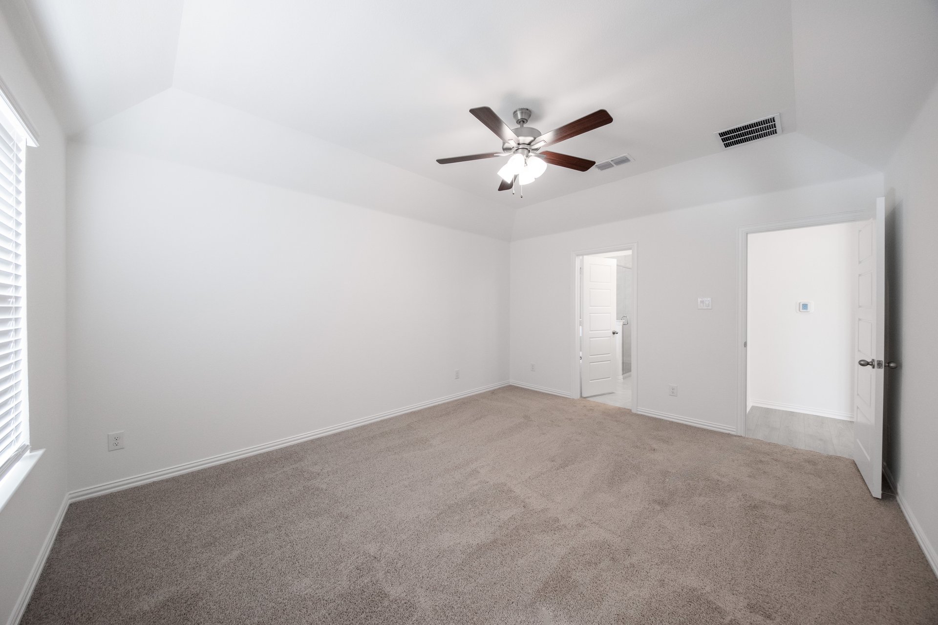 primary bedroom with carpet and windows