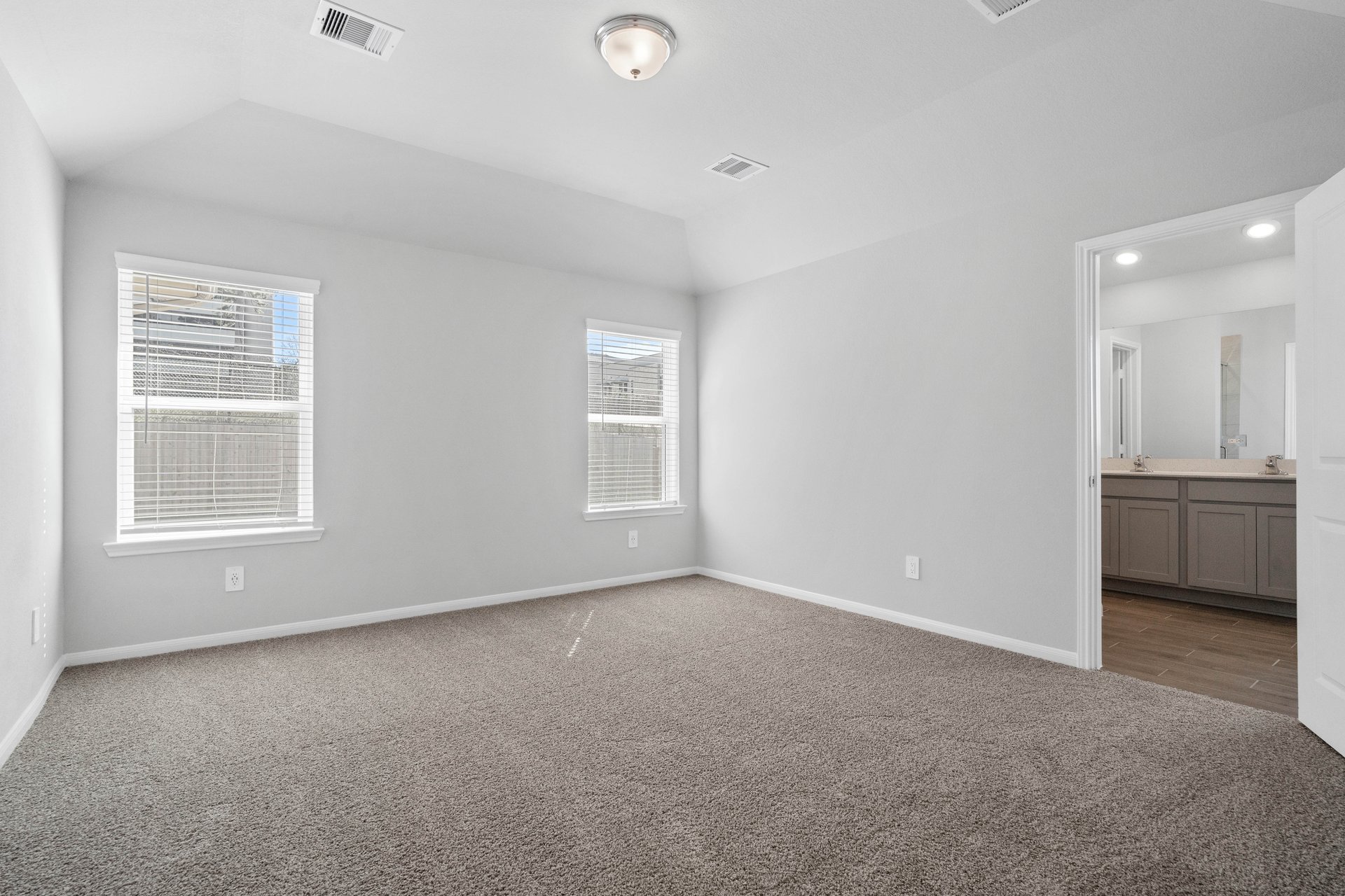 open primary bedroom with carpet