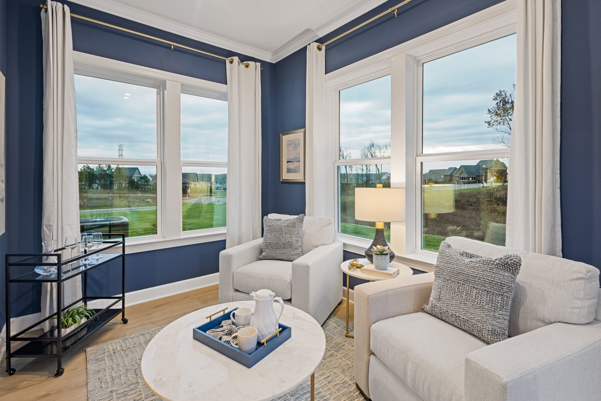 morning room with large windows, two chairs, a coffee table, and wood-tone flooring