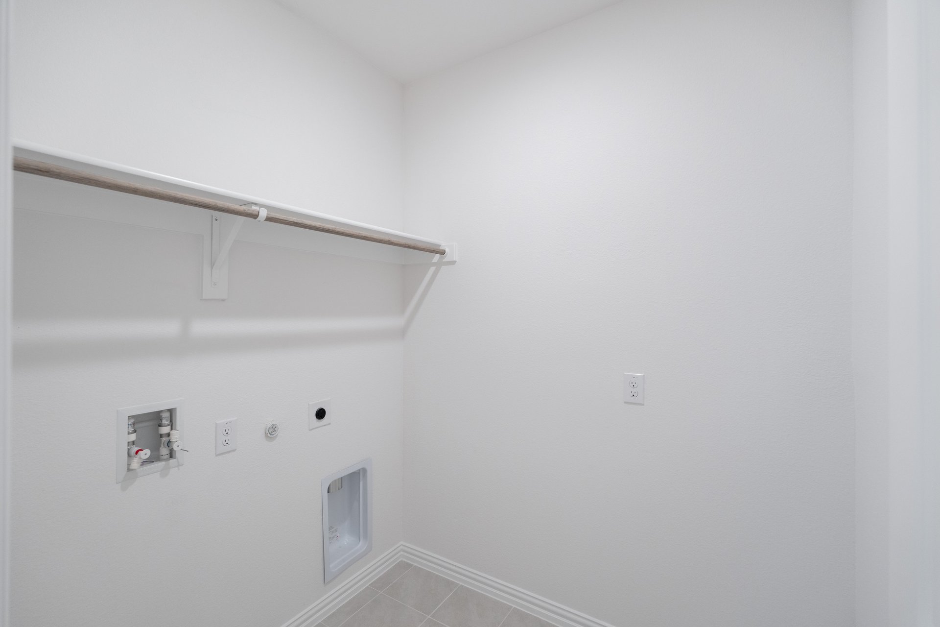 laundry room with tile floors and white shelf