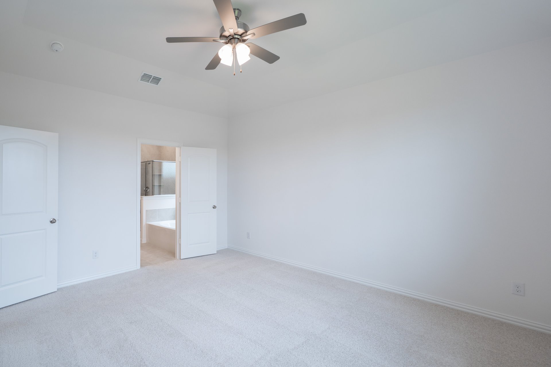 primary bedroom with carpet and ceiling fan