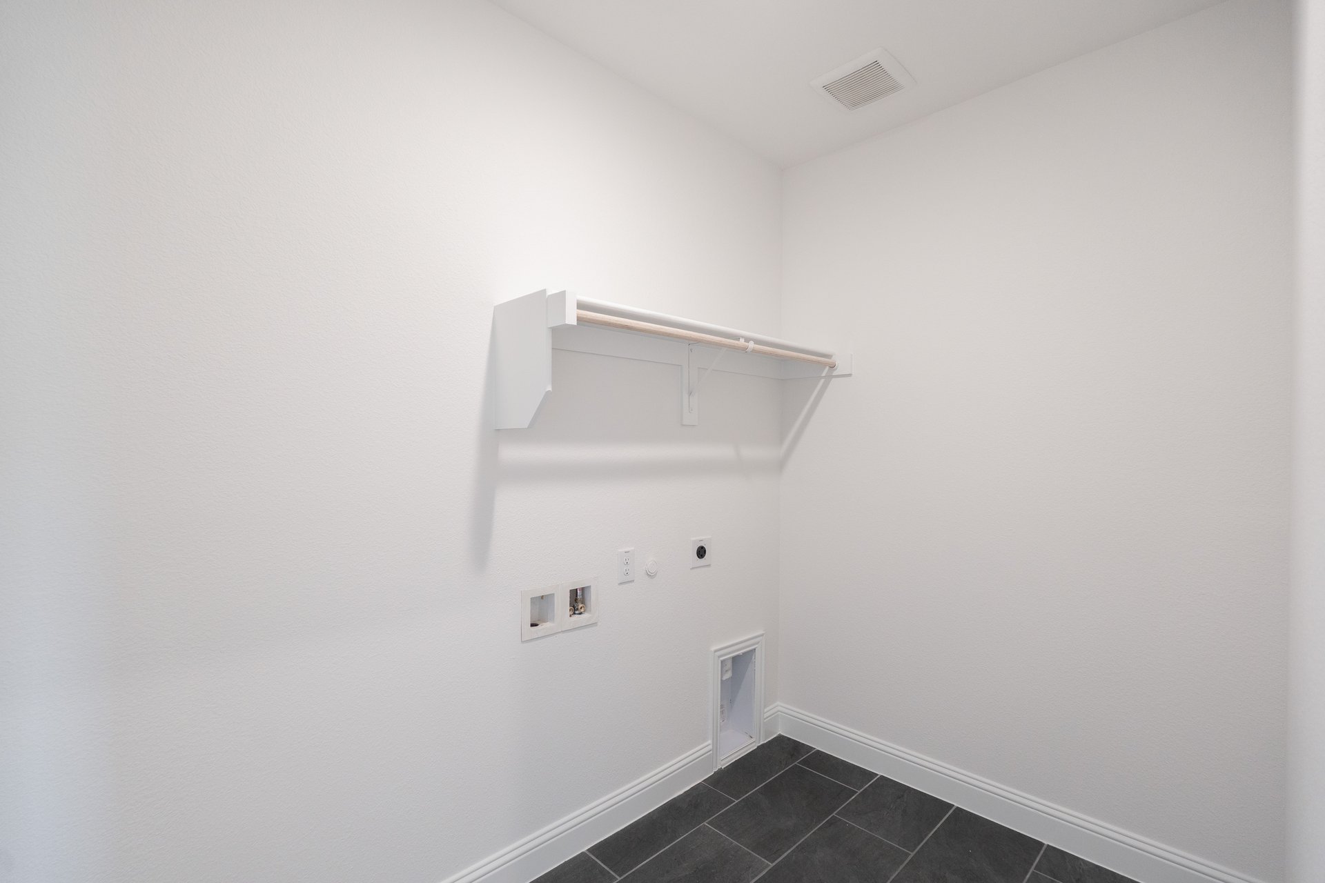 laundry room with tile floors and white shelf