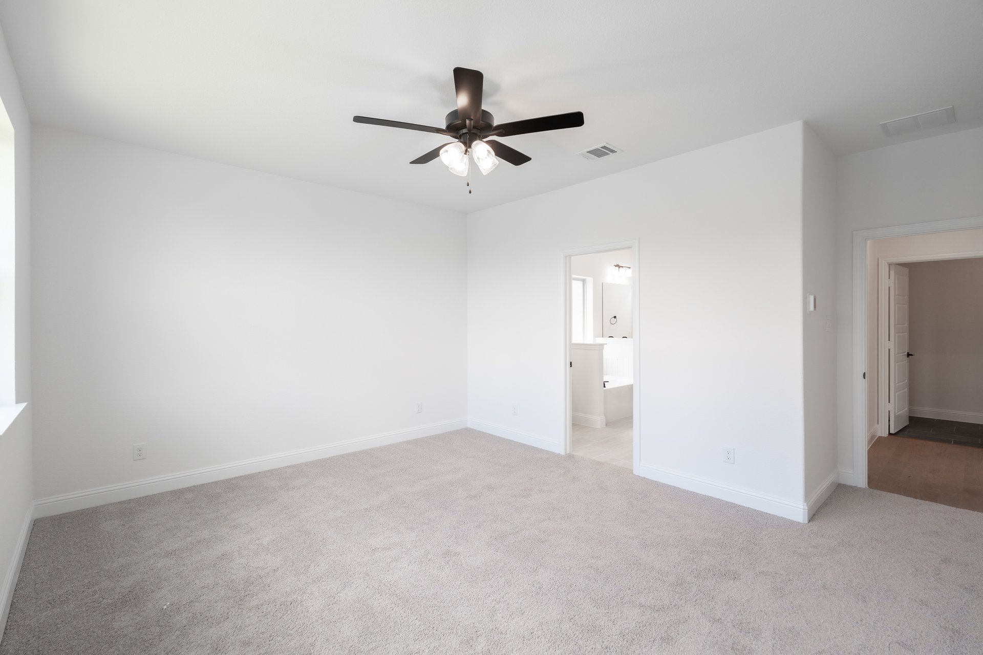 primary bedroom with carpet and ceiling fan