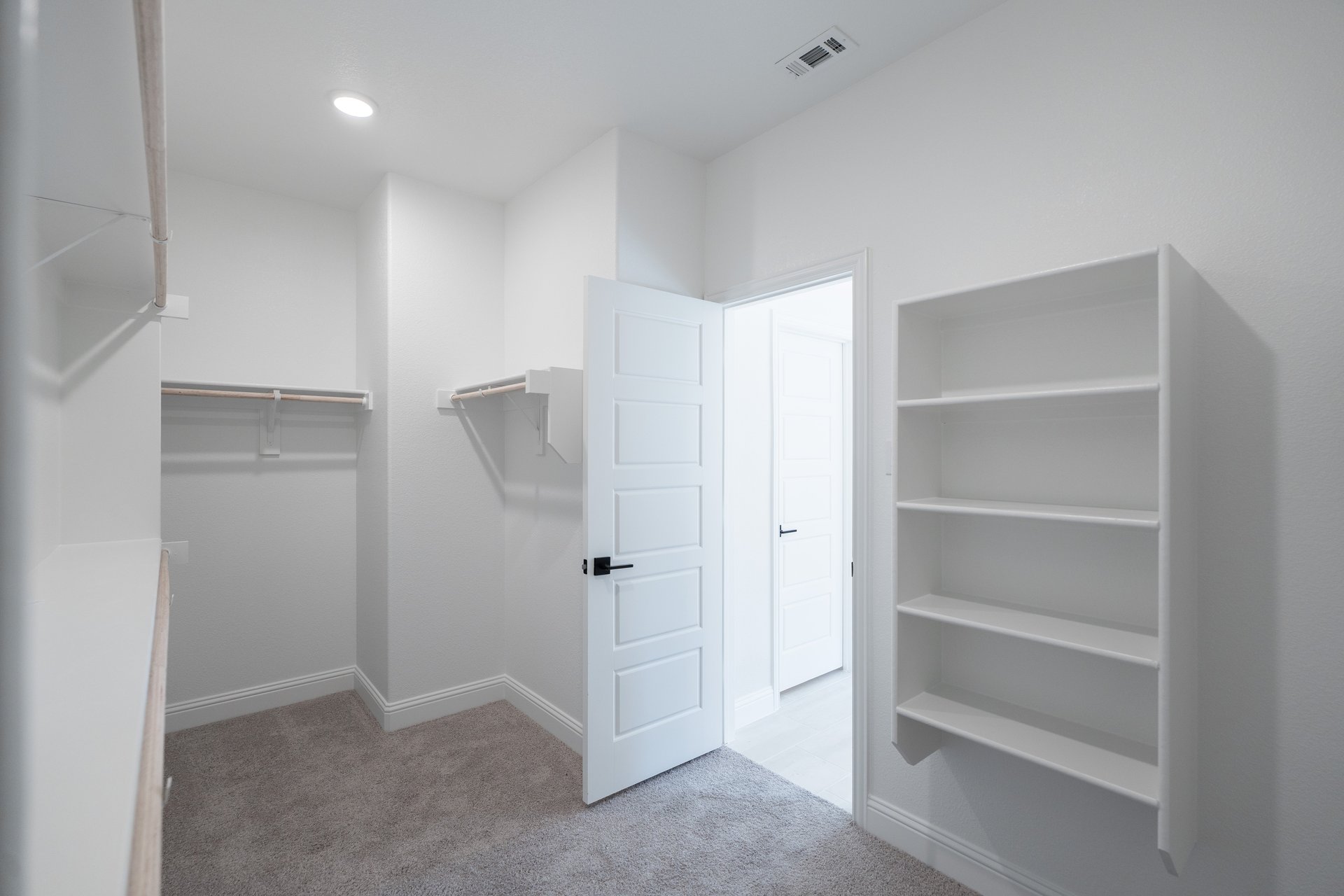 primary bedroom closet with carpet and white shelves