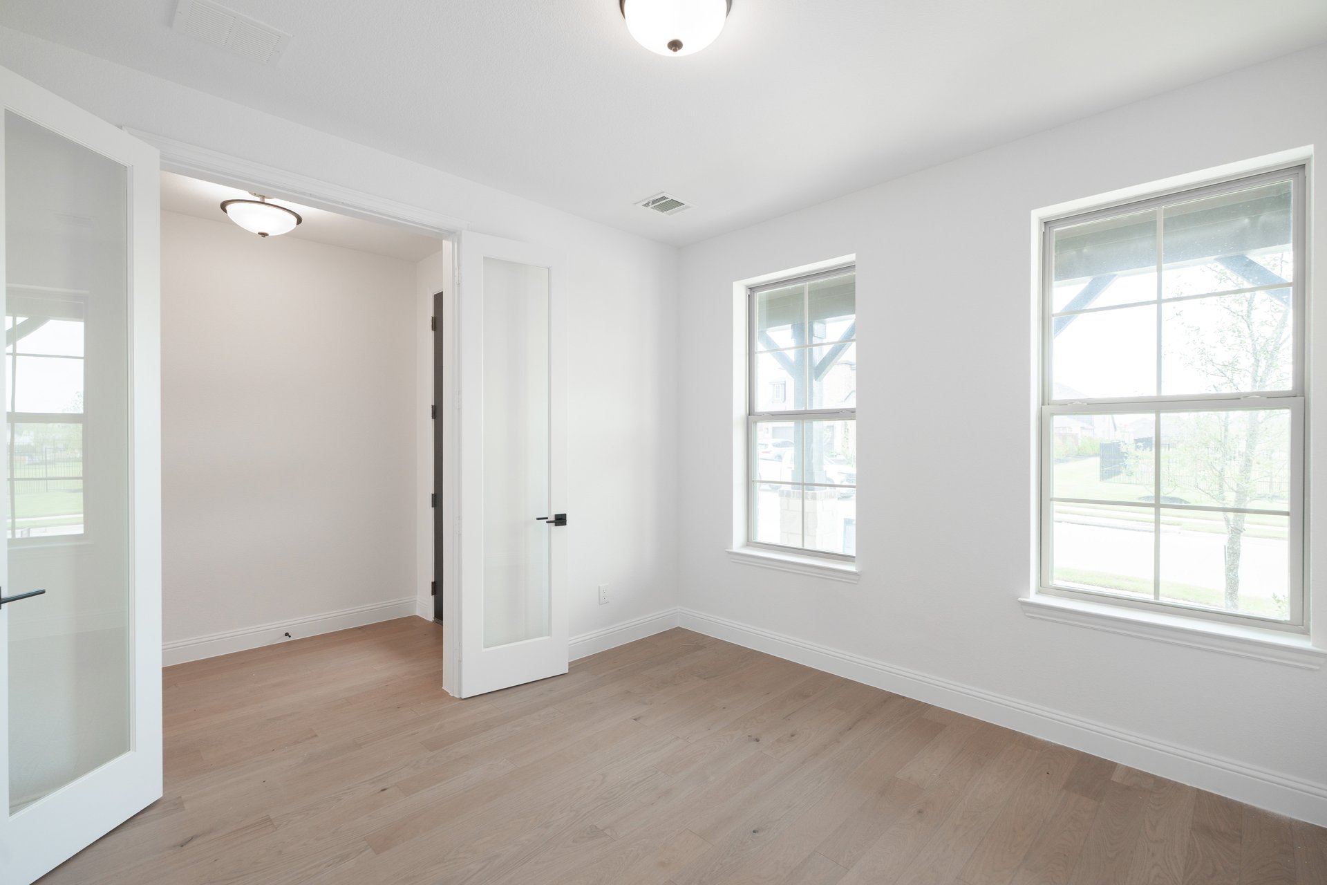 private study with wood floors and windows