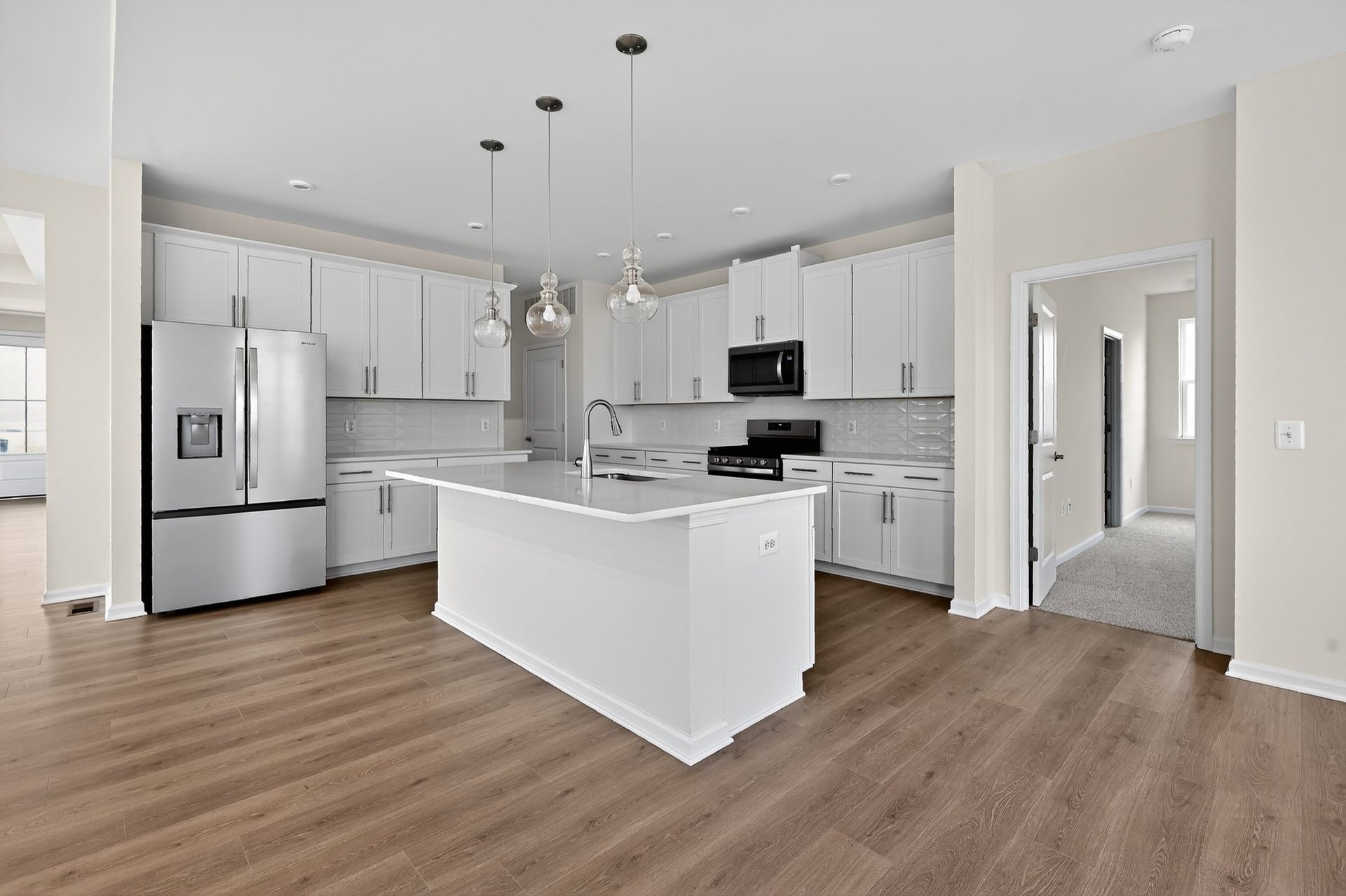 primary kitchen with large island and three pendants