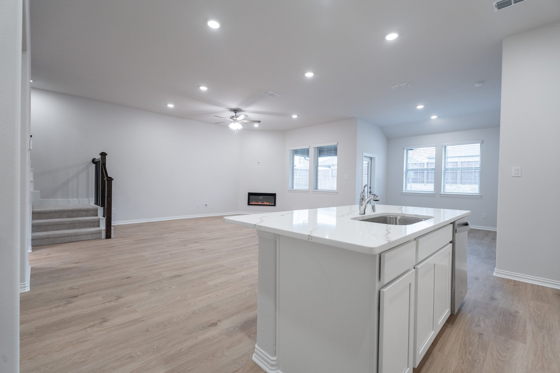 open kitchen with wood floors and white cabinets