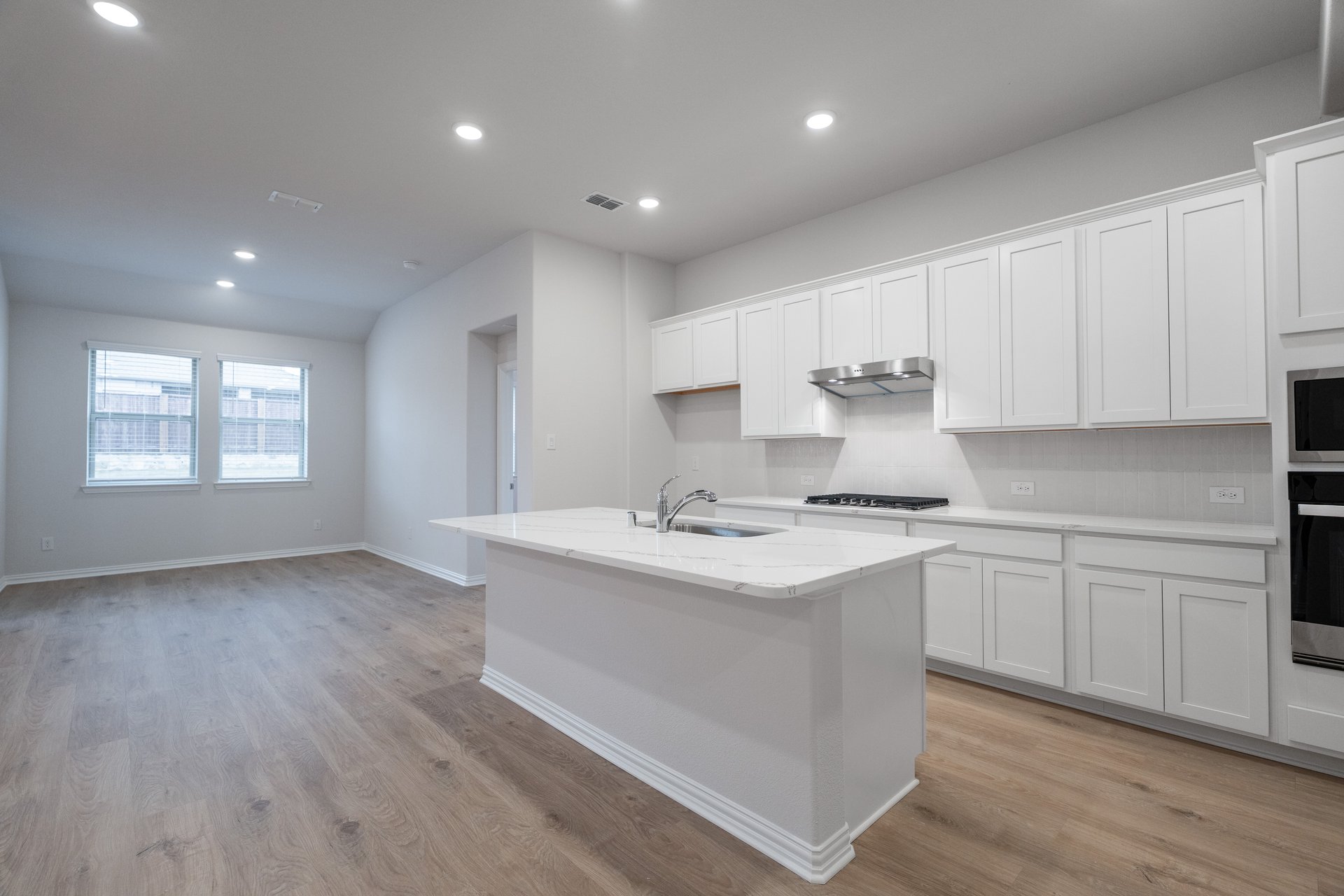 open kitchen with wood floors and white cabinets