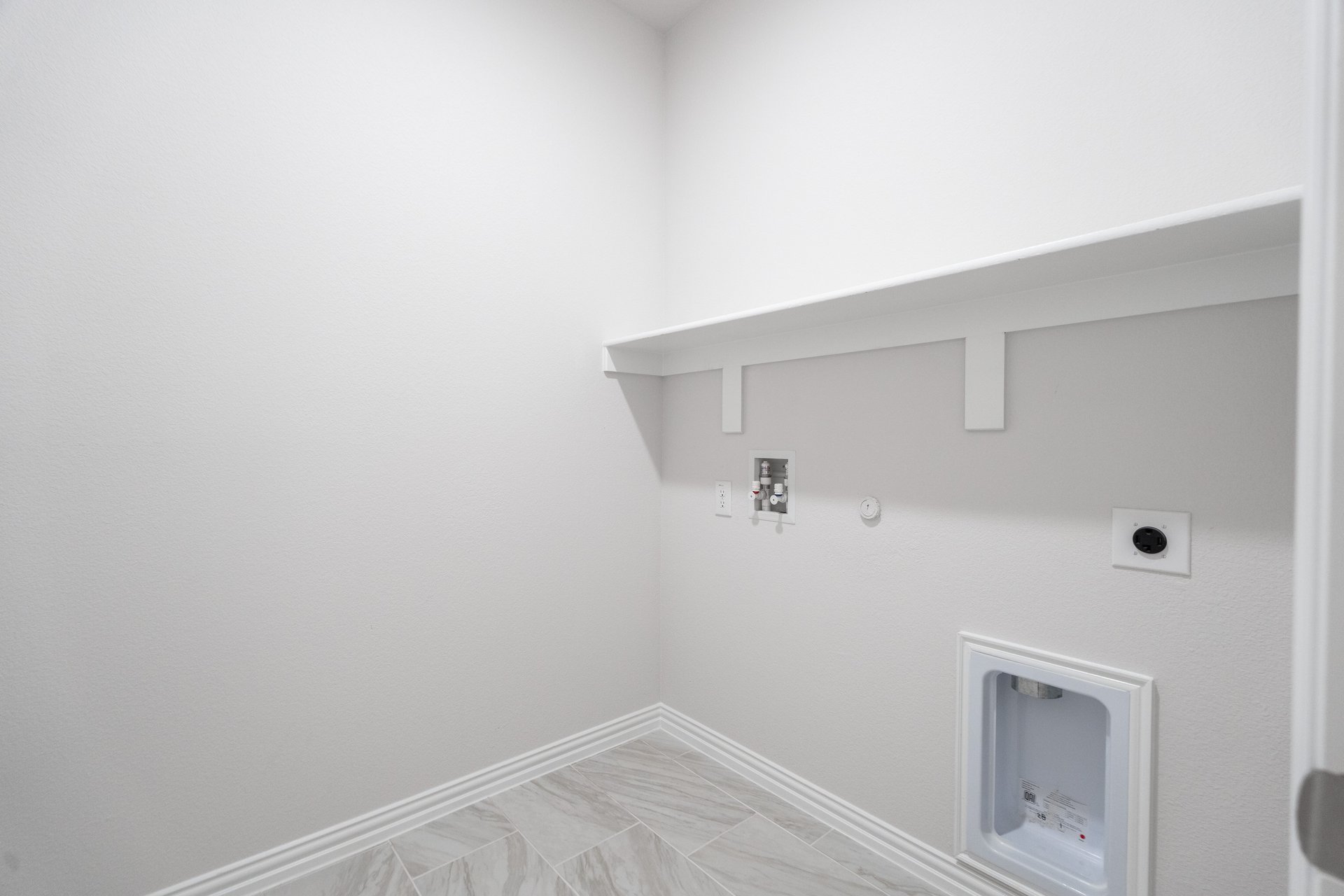 laundry room with tile floors and white shelf
