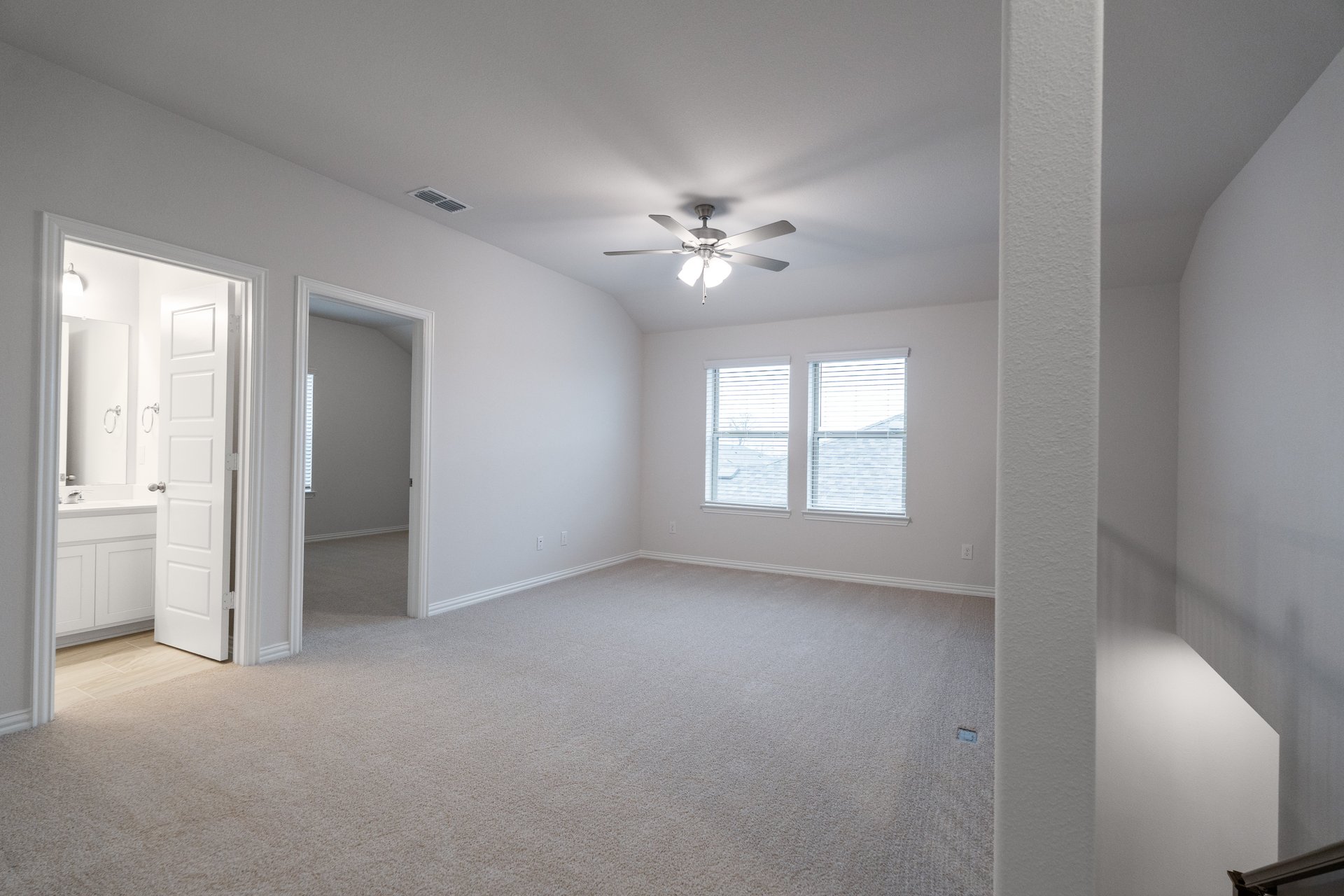 open loft with carpet and ceiling fan