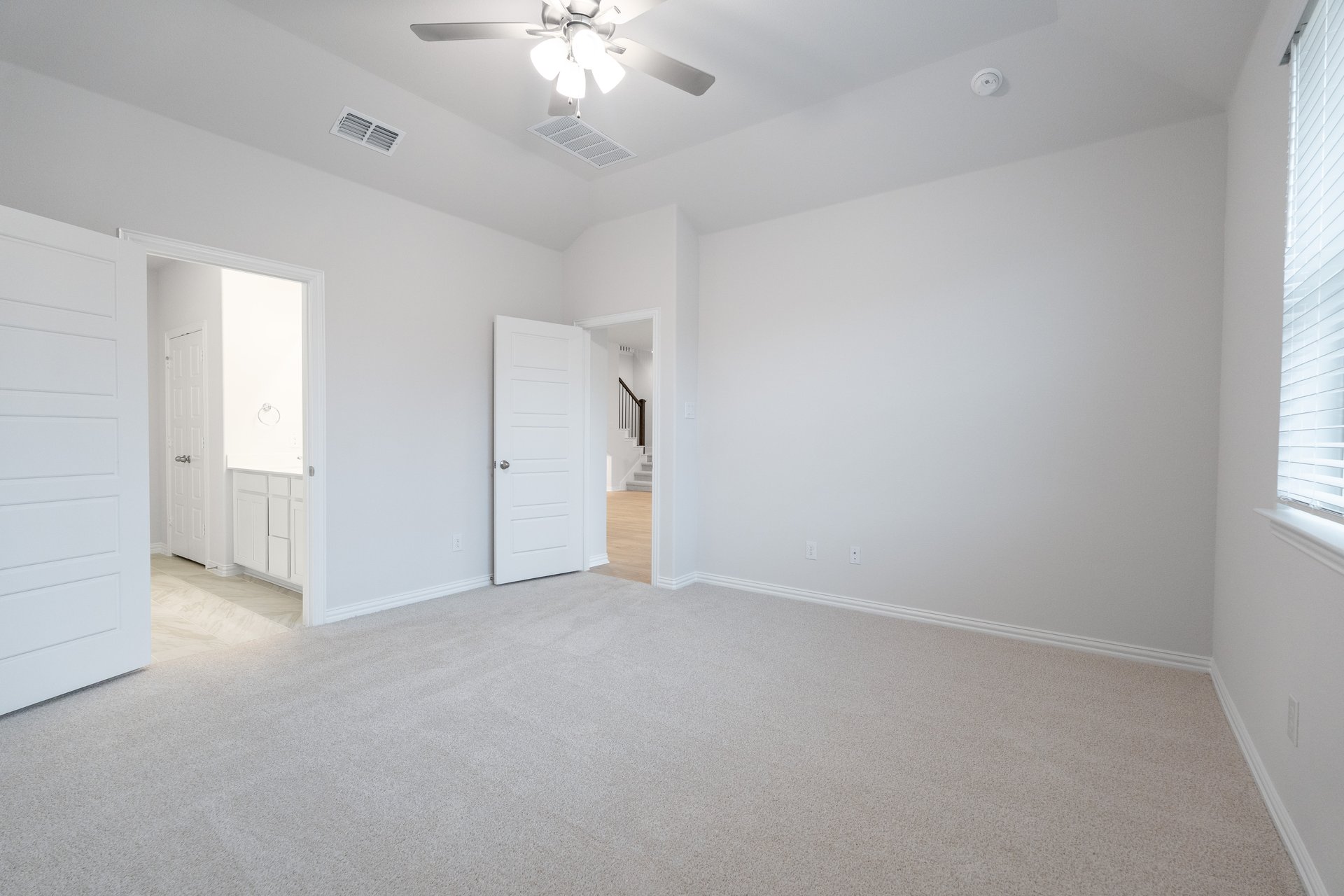primary bedroom with carpet and windows