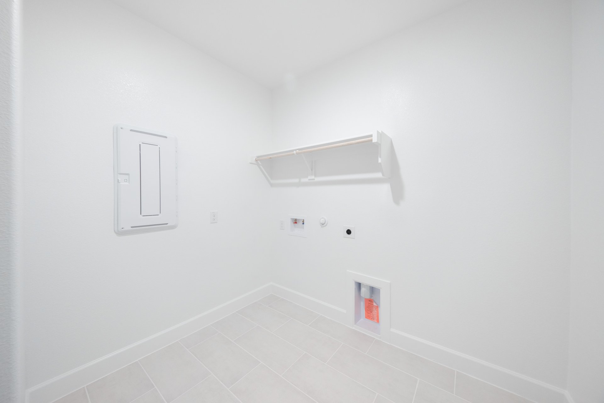 laundry room with tile floors and white shelf