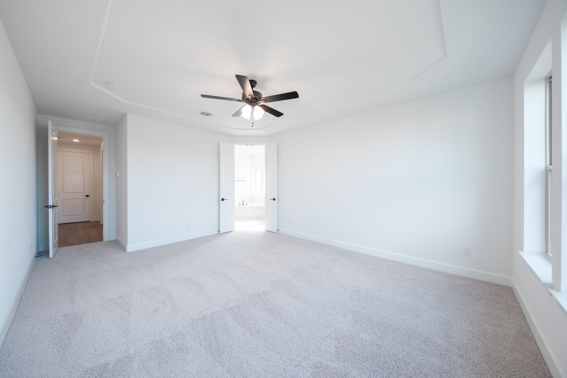 primary bedroom with carpet and ceiling fan