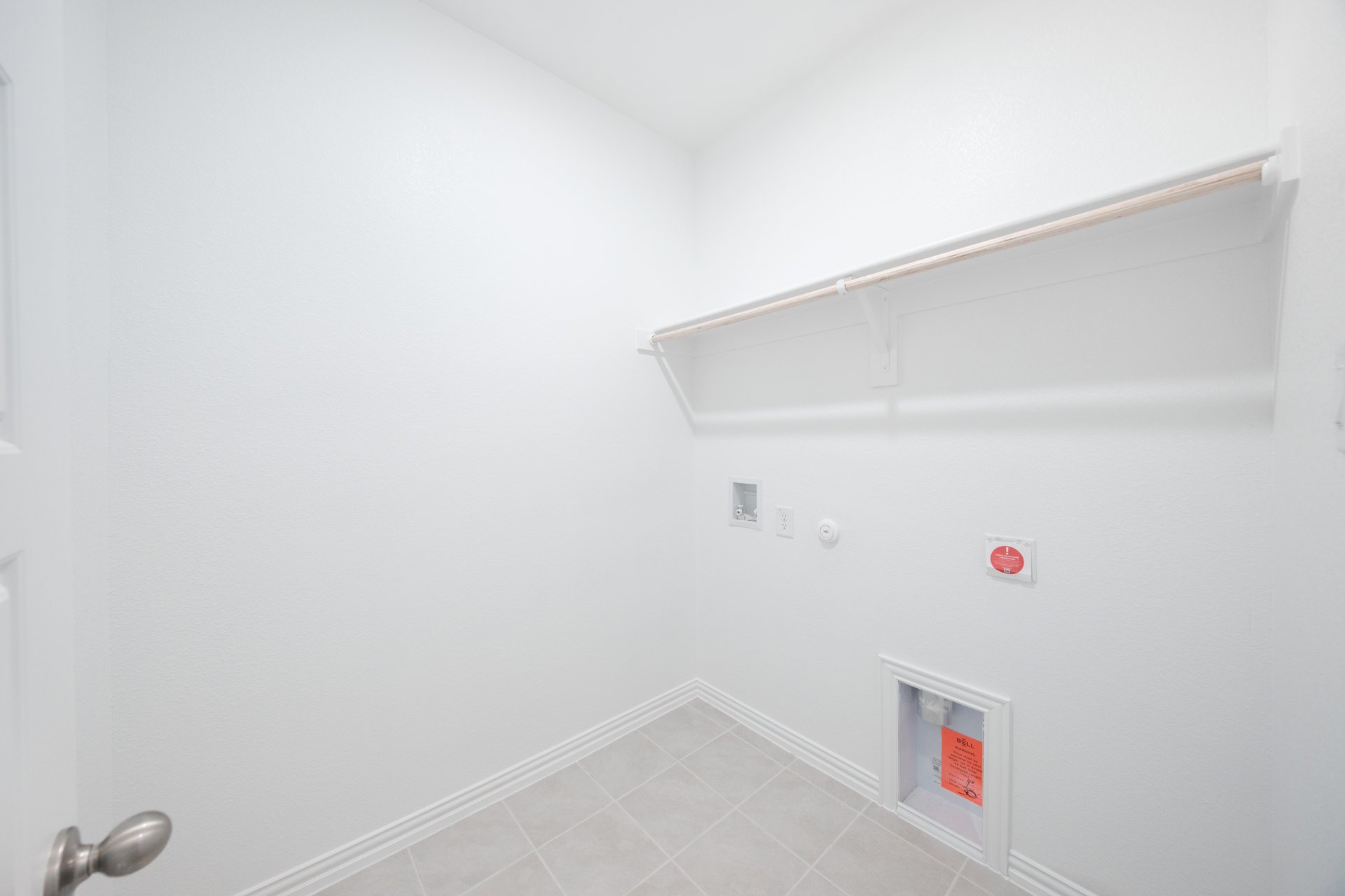 laundry room with tile floors and white shelf