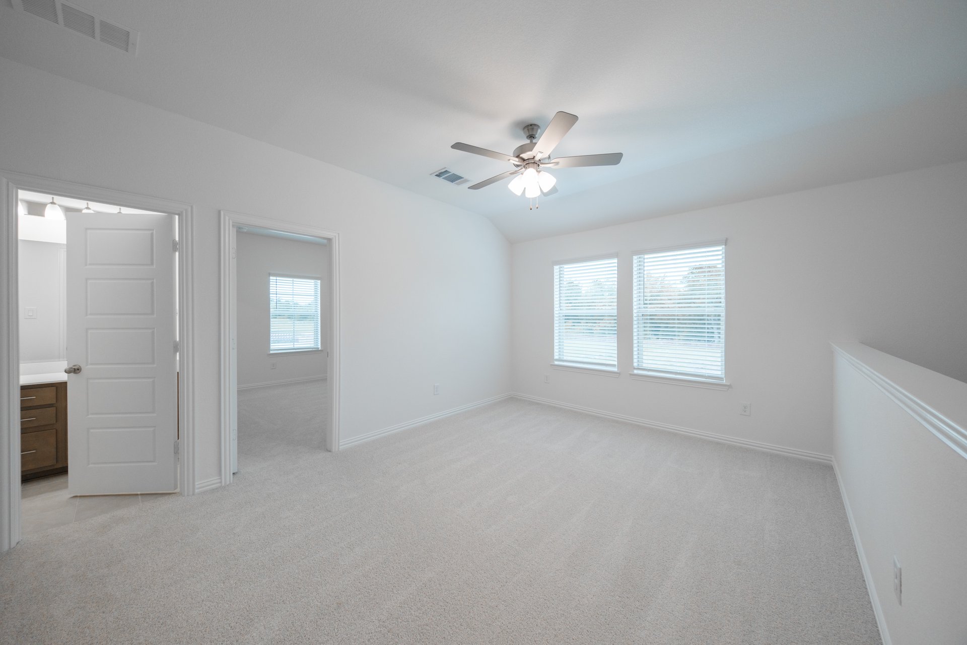 open loft with carpet, window, and ceiling fan