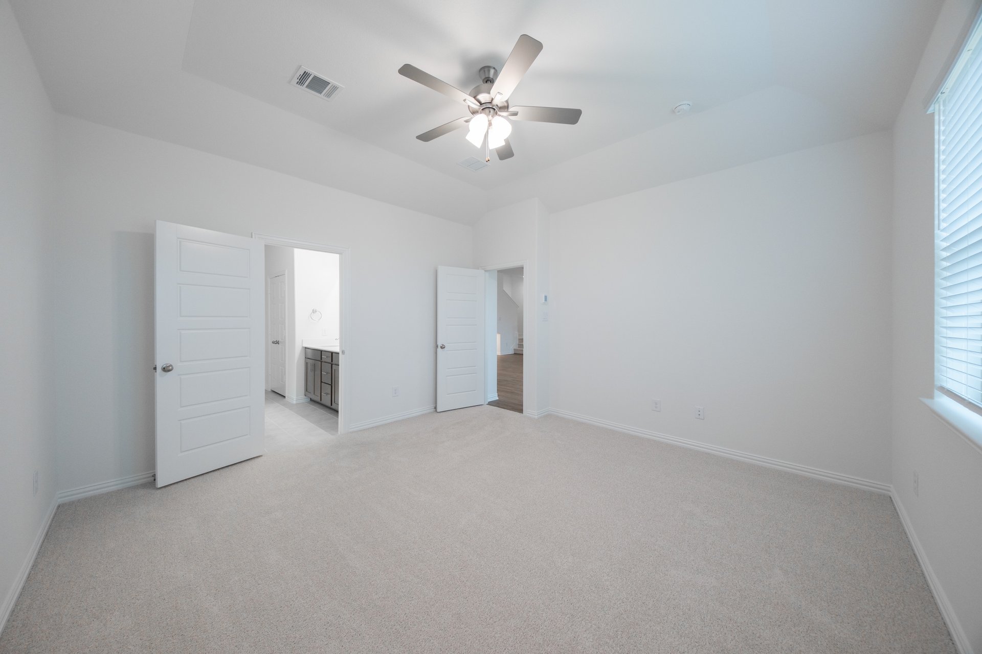 primary bedroom with carpet and ceiling fan